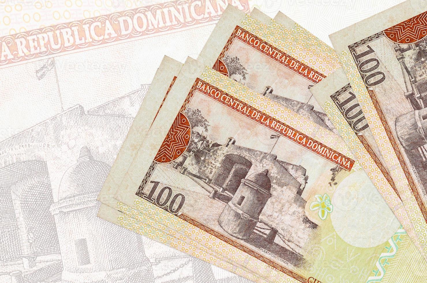 100 Dominican peso bills lies in stack on background of big semi-transparent banknote. Abstract presentation of national currency photo