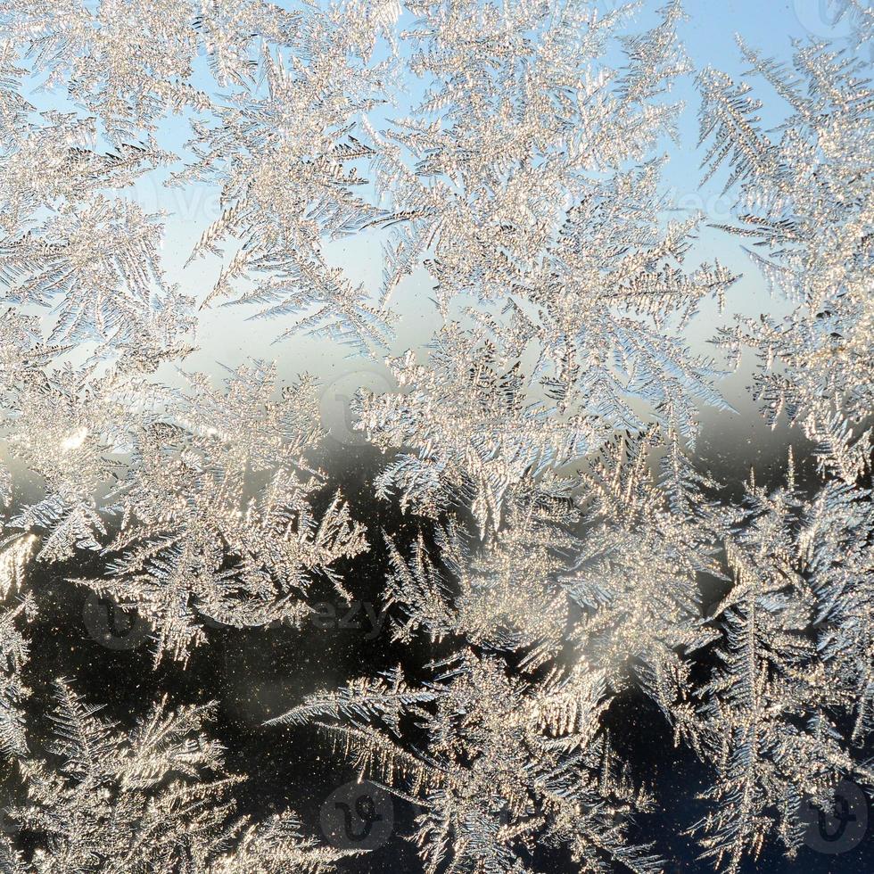 Snowflakes frost rime macro on window glass pane photo