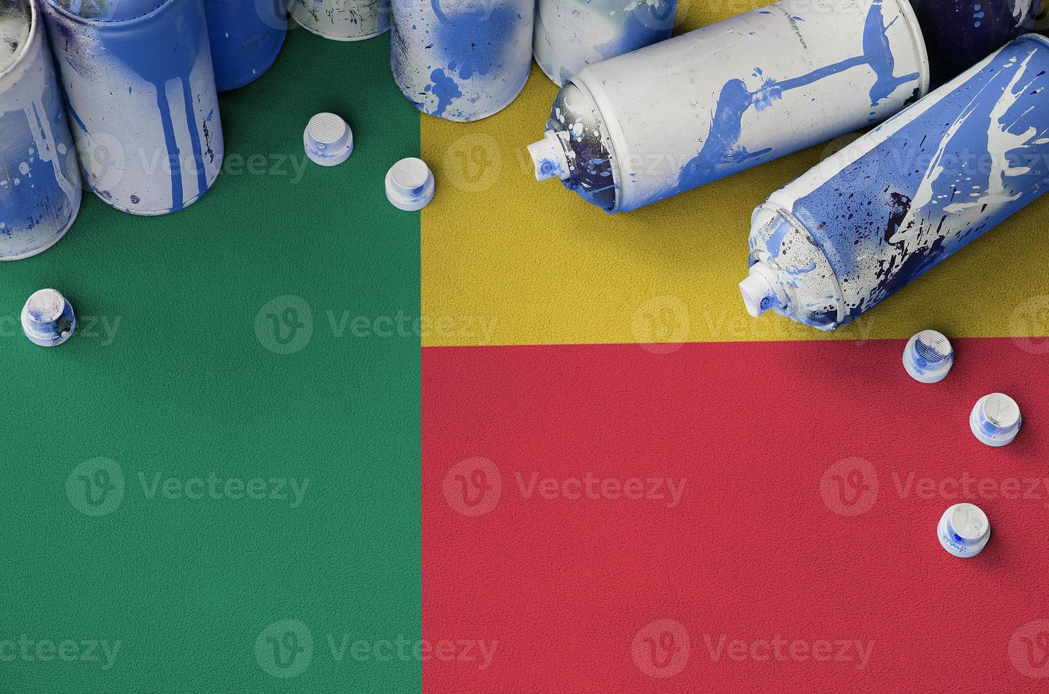 Benin flag and few used aerosol spray cans for graffiti painting. Street art culture concept photo