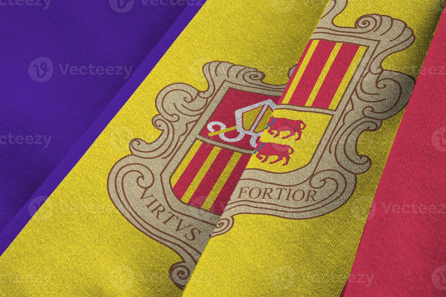 bandera de andorra con grandes pliegues ondeando de cerca bajo la luz del estudio en el interior. los símbolos y colores oficiales en banner foto