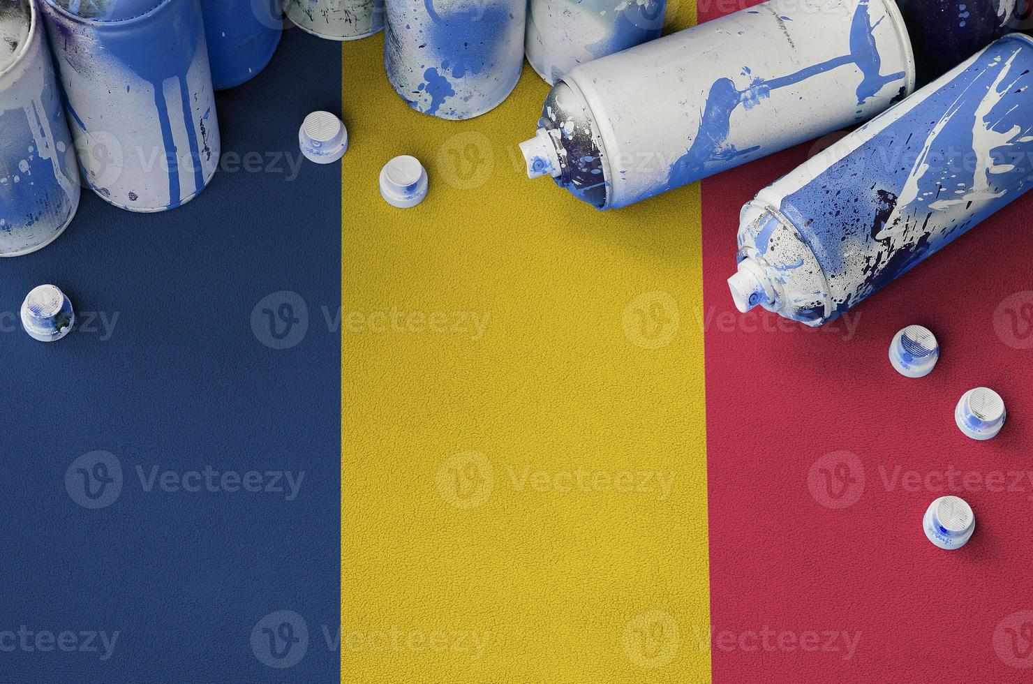Chad flag and few used aerosol spray cans for graffiti painting. Street art culture concept photo