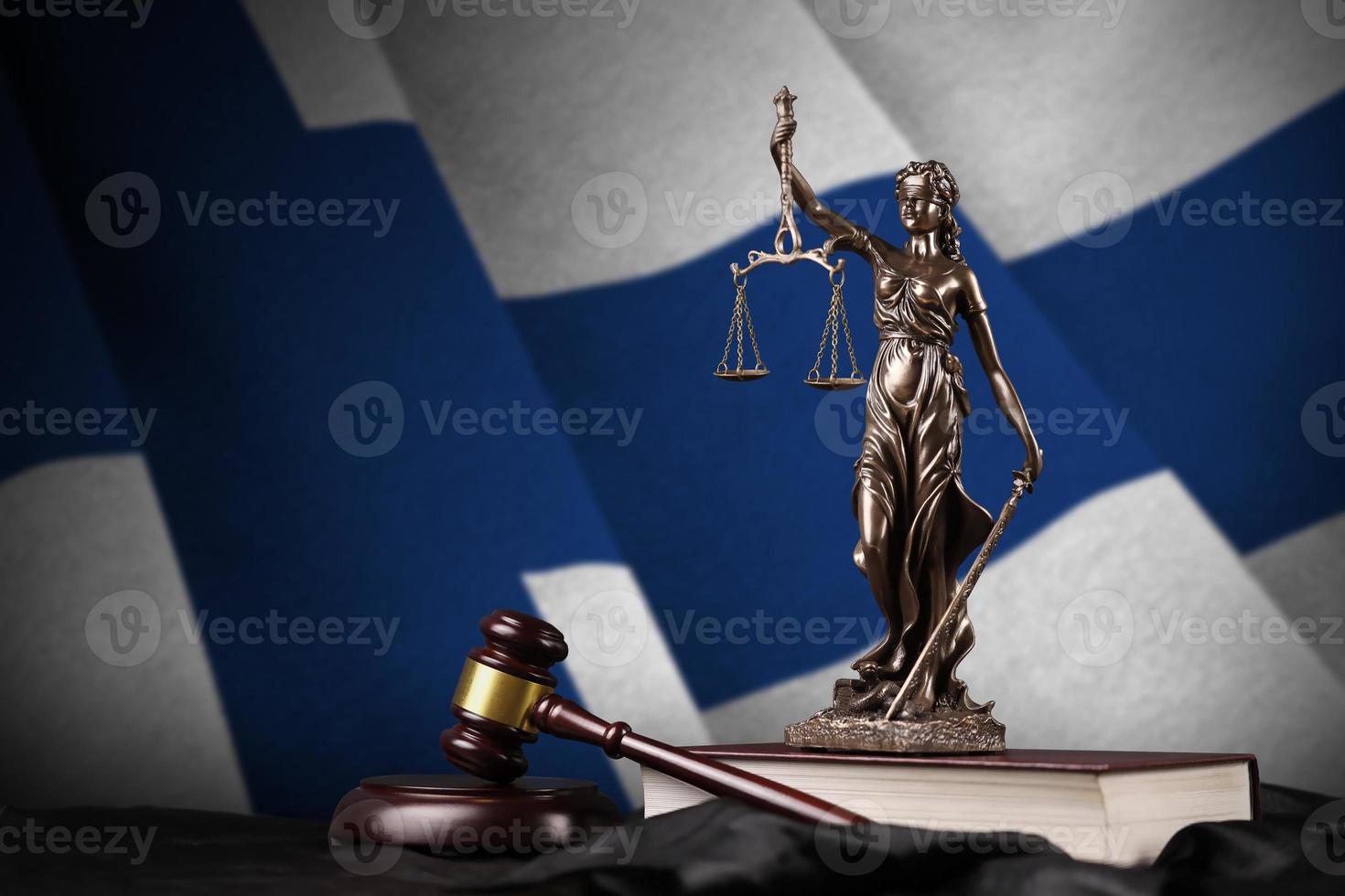 Finland flag with statue of lady justice, constitution and judge hammer on black drapery. Concept of judgement and guilt photo