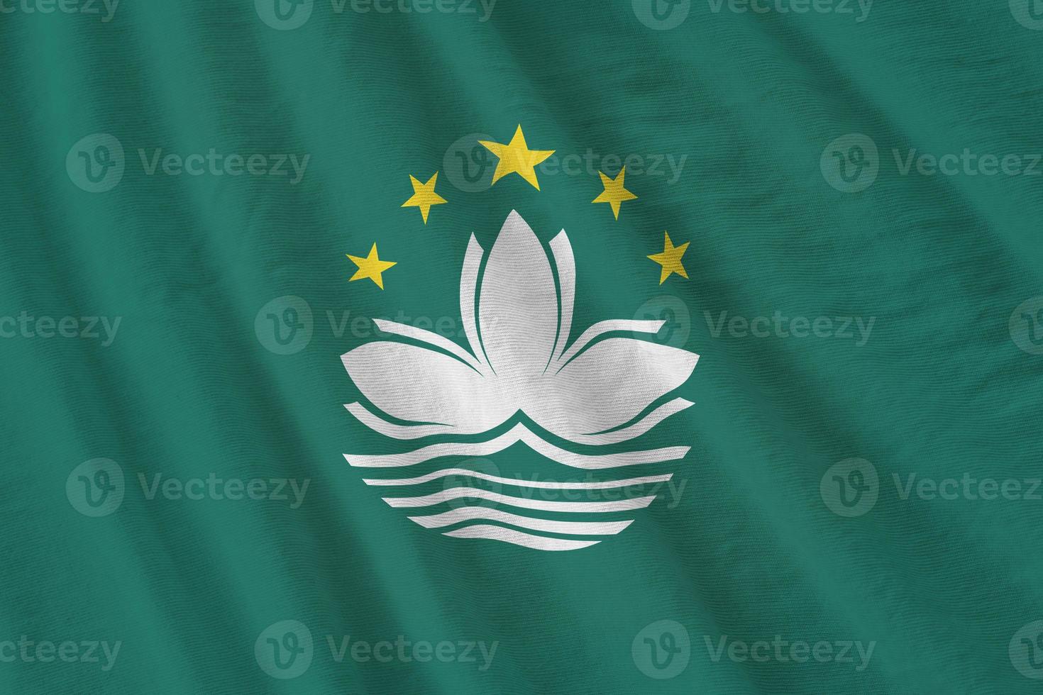 Macau flag with big folds waving close up under the studio light indoors. The official symbols and colors in banner photo