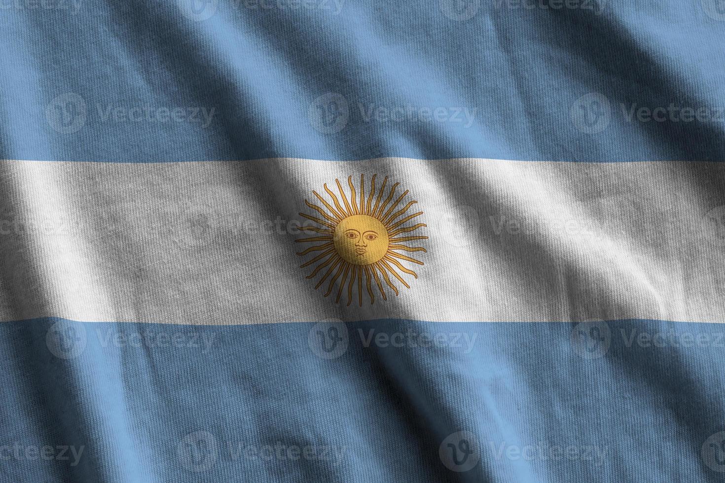Argentina flag with big folds waving close up under the studio light indoors. The official symbols and colors in banner photo