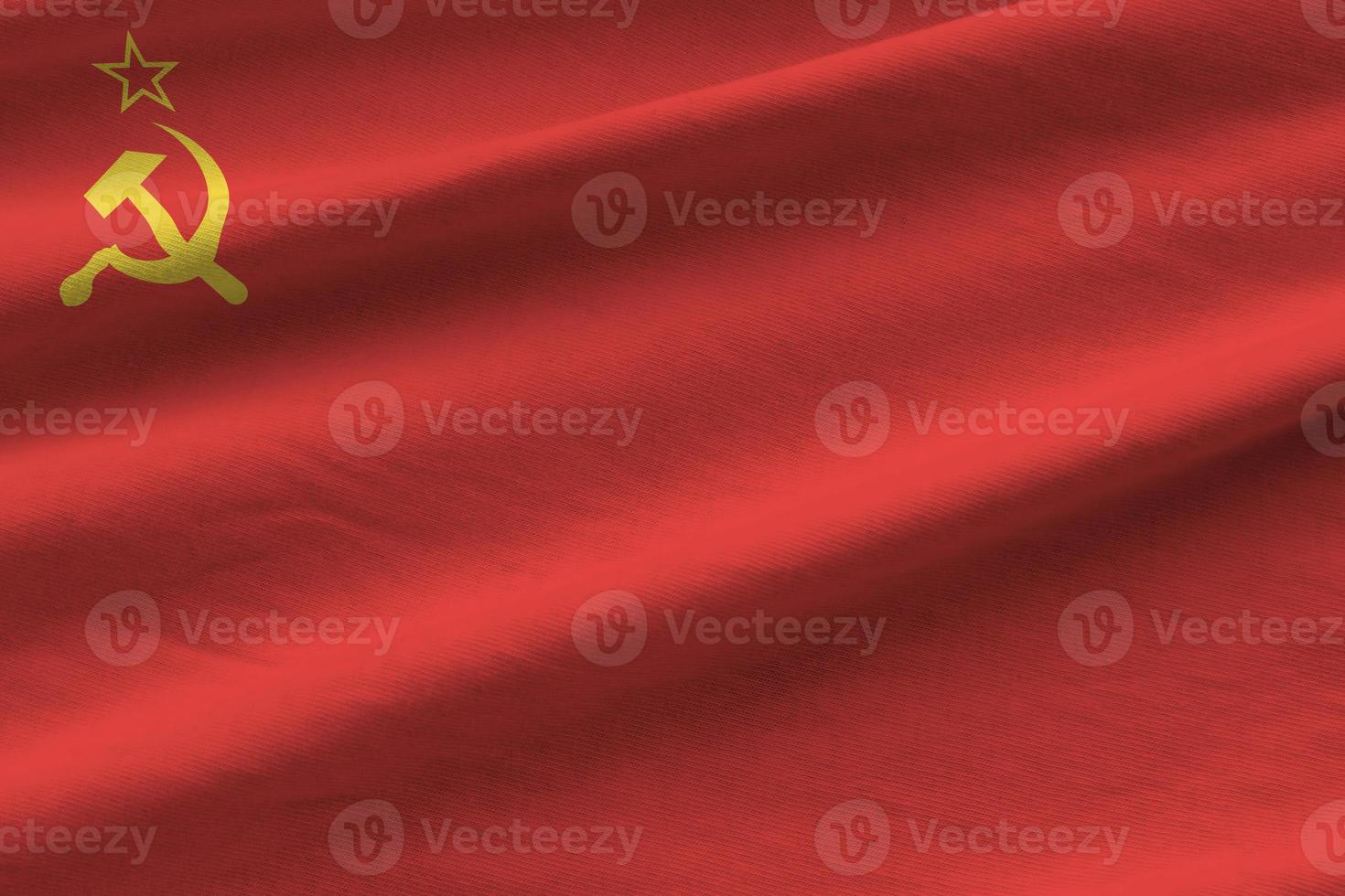 Soviet Union flag with big folds waving close up under the studio light indoors. The official symbols and colors in banner photo