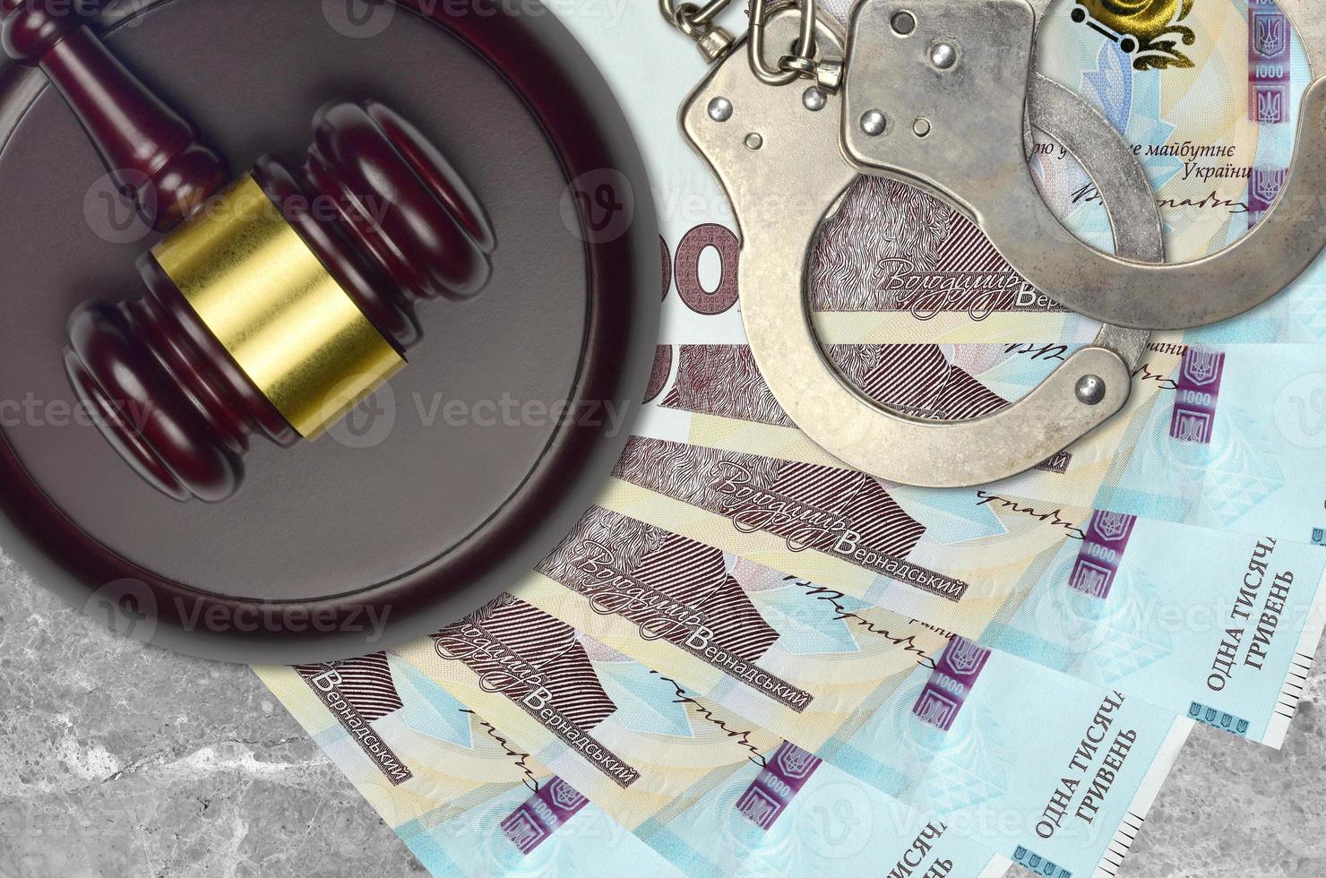 1000 Ukrainian hryvnias bills and judge hammer with police handcuffs on court desk. Concept of judicial trial or bribery. Tax avoidance photo