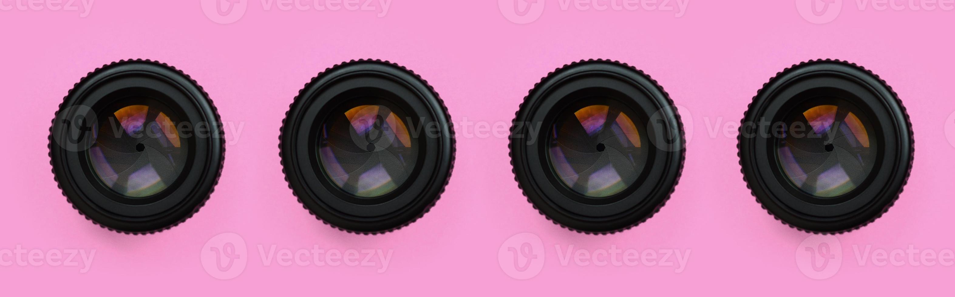 A few camera lenses with a closed aperture lie on texture background of fashion pastel pink color paper in minimal concept. Abstract trendy pattern photo