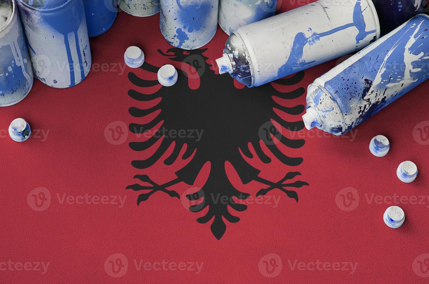 Albania flag and few used aerosol spray cans for graffiti painting. Street art culture concept photo