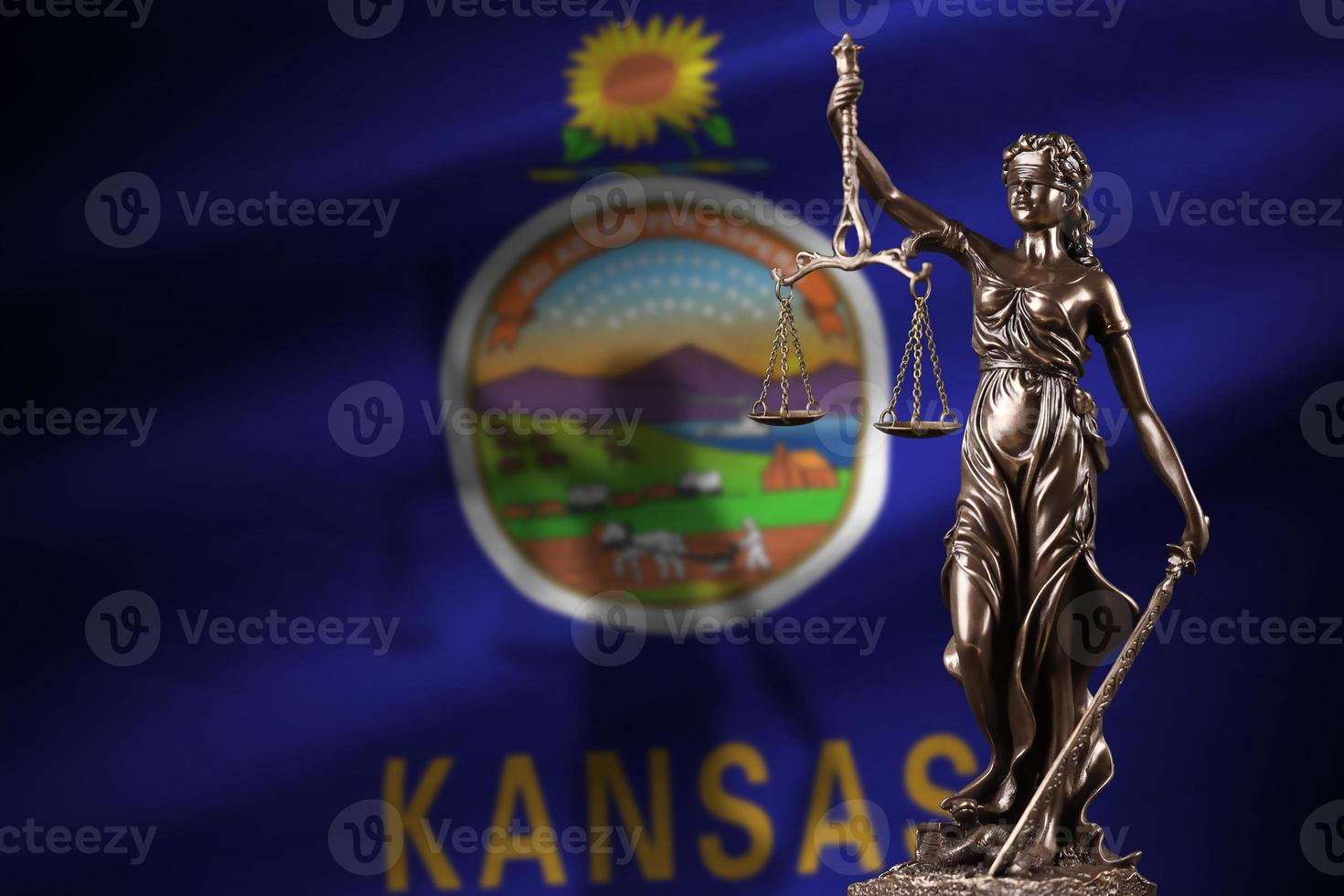 Kansas US state flag with statue of lady justice and judicial scales in dark room. Concept of judgement and punishment photo