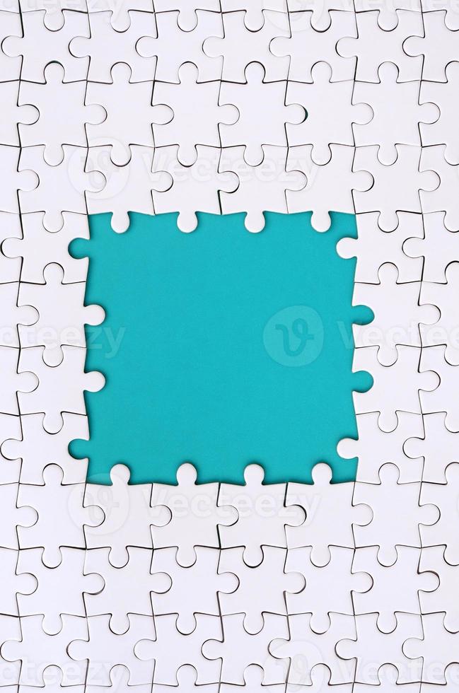Framing in the form of a rectangle, made of a white jigsaw puzzle around the blue space photo