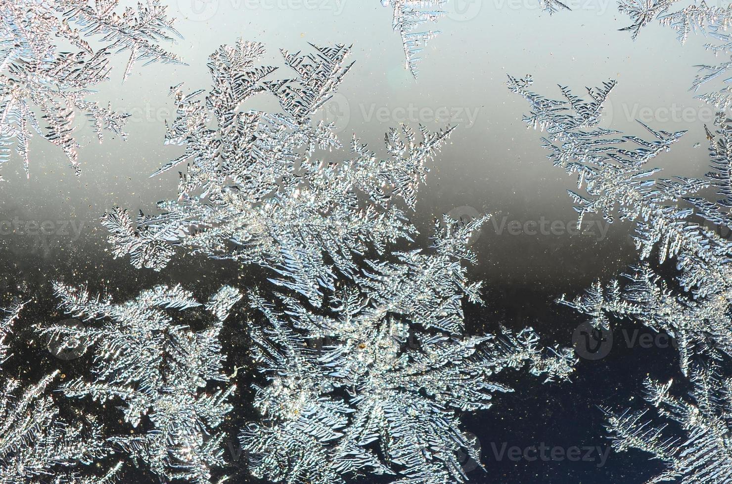 Snowflakes frost rime macro on window glass pane photo