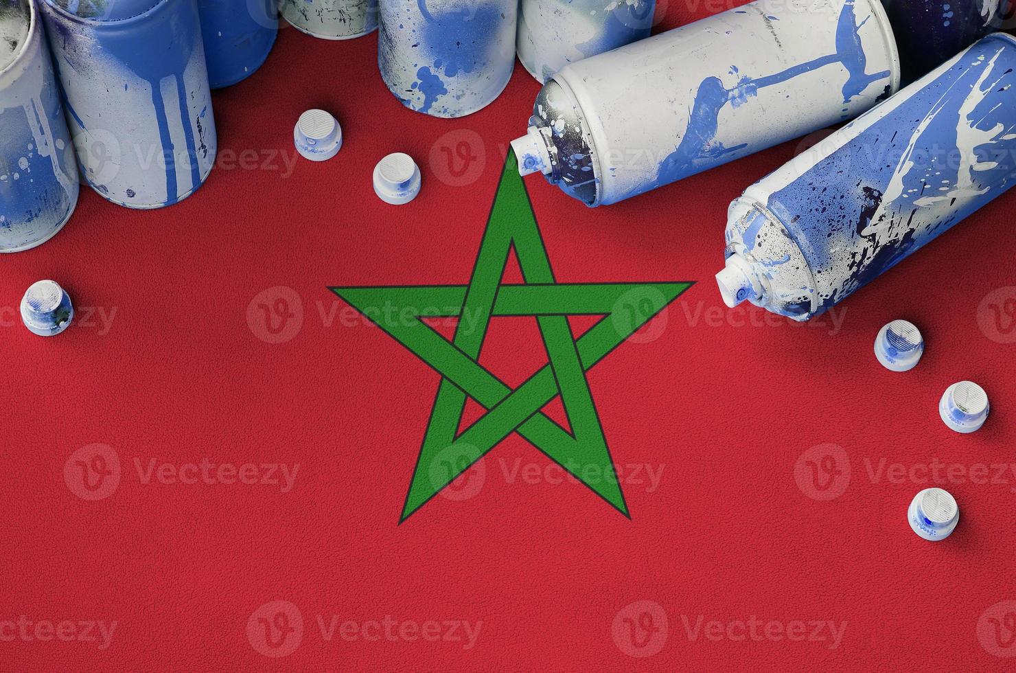 bandera de marruecos y pocas latas de aerosol usadas para pintar graffiti. concepto de cultura de arte callejero foto