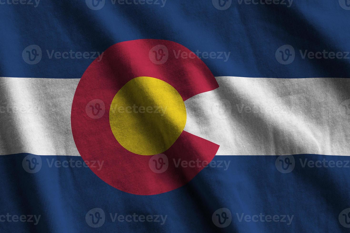 Colorado US state flag with big folds waving close up under the studio light indoors. The official symbols and colors in banner photo