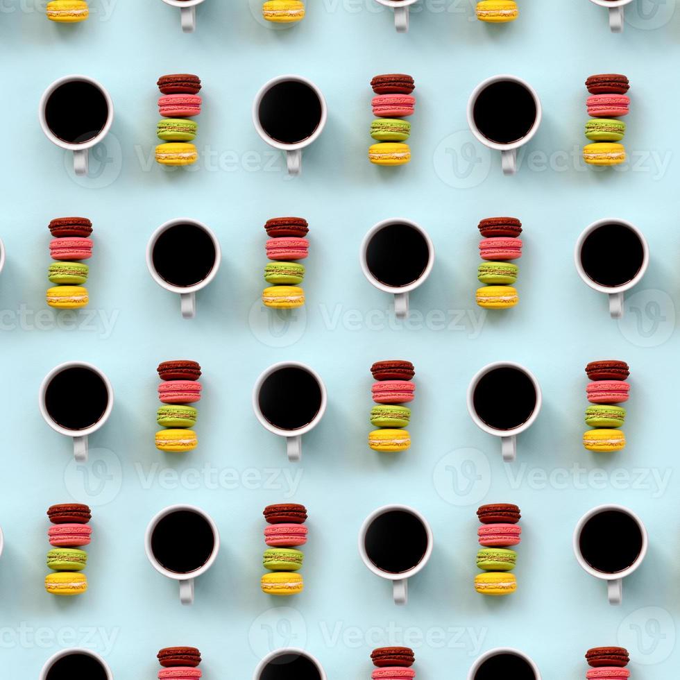 A pattern of many colorful dessert cake macaroon and coffee cups on trendy pastel blue background top view. Flat lay composition photo