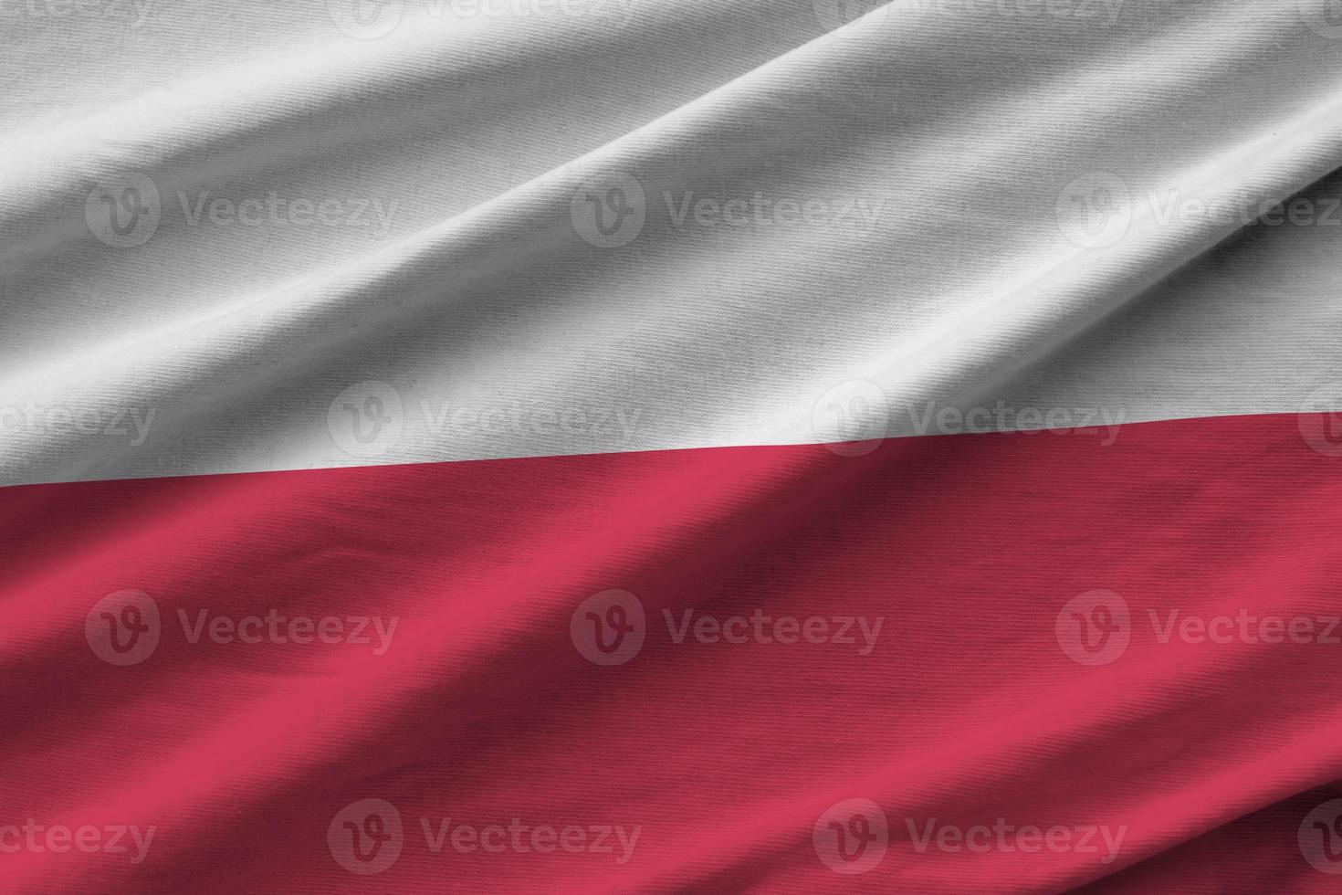 Poland flag with big folds waving close up under the studio light indoors. The official symbols and colors in banner photo