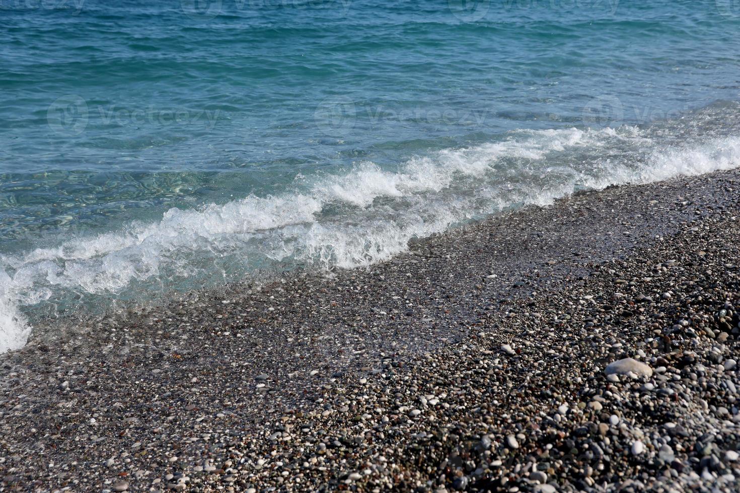 banco de guijarros con el mar y la playa al fondo foto