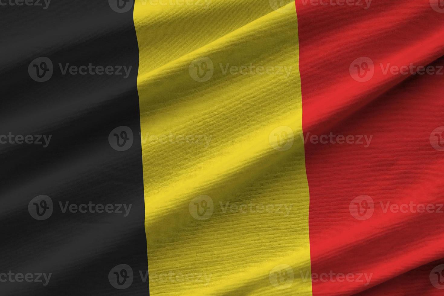 Belgium flag with big folds waving close up under the studio light indoors. The official symbols and colors in banner photo