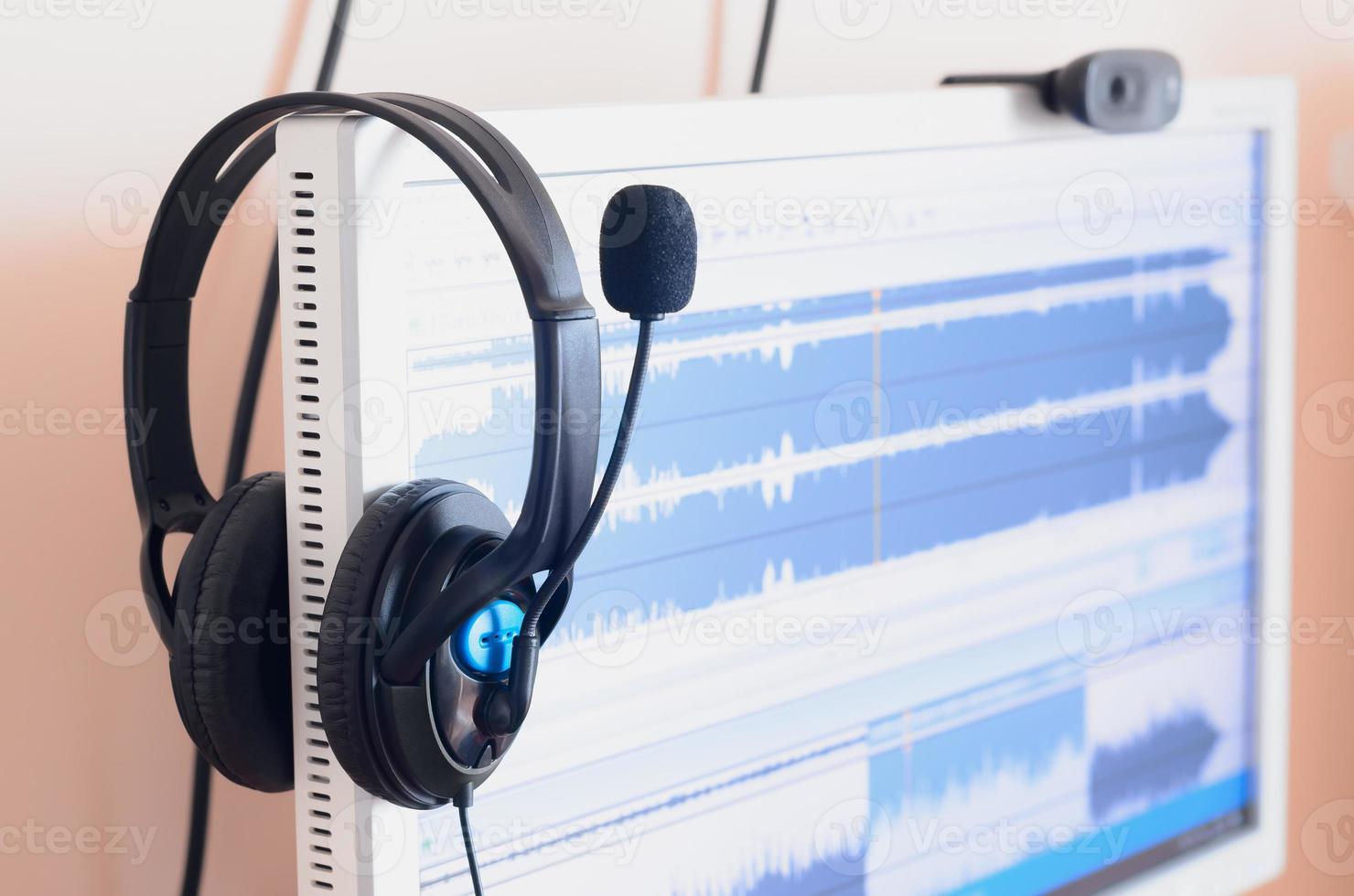 Big black headphones lie on the wooden desktop of the sound designer photo