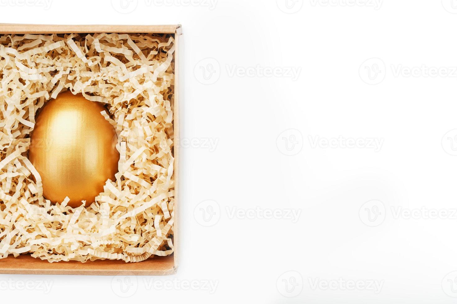 Golden egg in a box on a white background concept of exclusivity, best choice, prize, special surprise, expensive gift. The concept of minimalism. photo