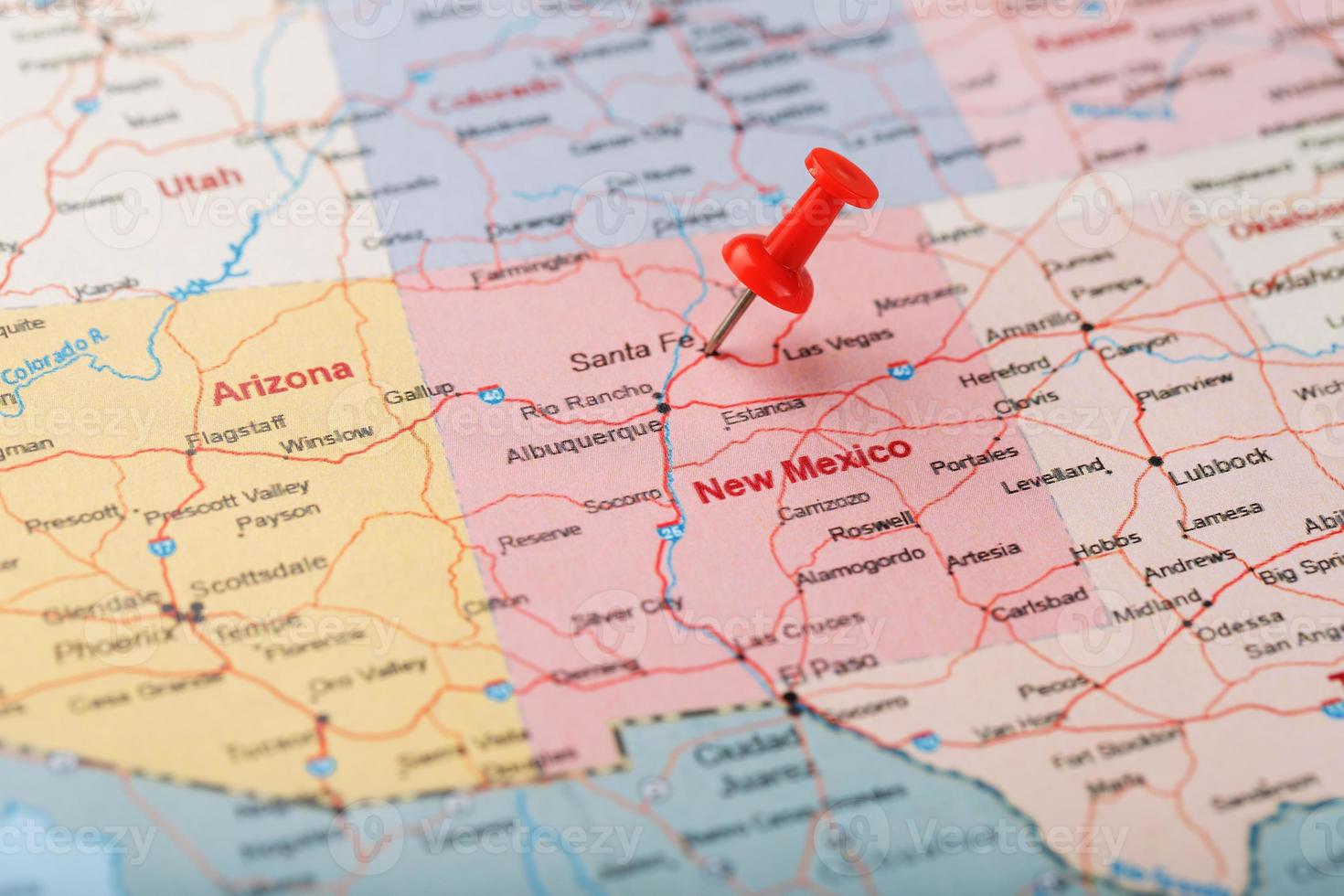 Red clerical needle on a map of USA, New Mexico and the capital of Santa Fe. Close up map of new mexico with red tack photo