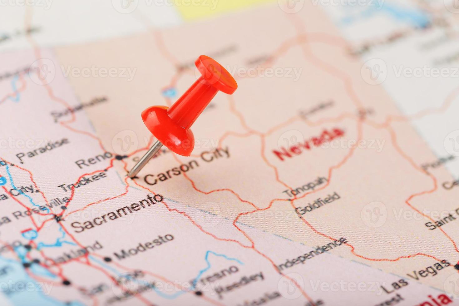 Red clerical needle on a map of USA, Nevada and the capital Carson City. Closeup Map Nevada with Red Tack photo