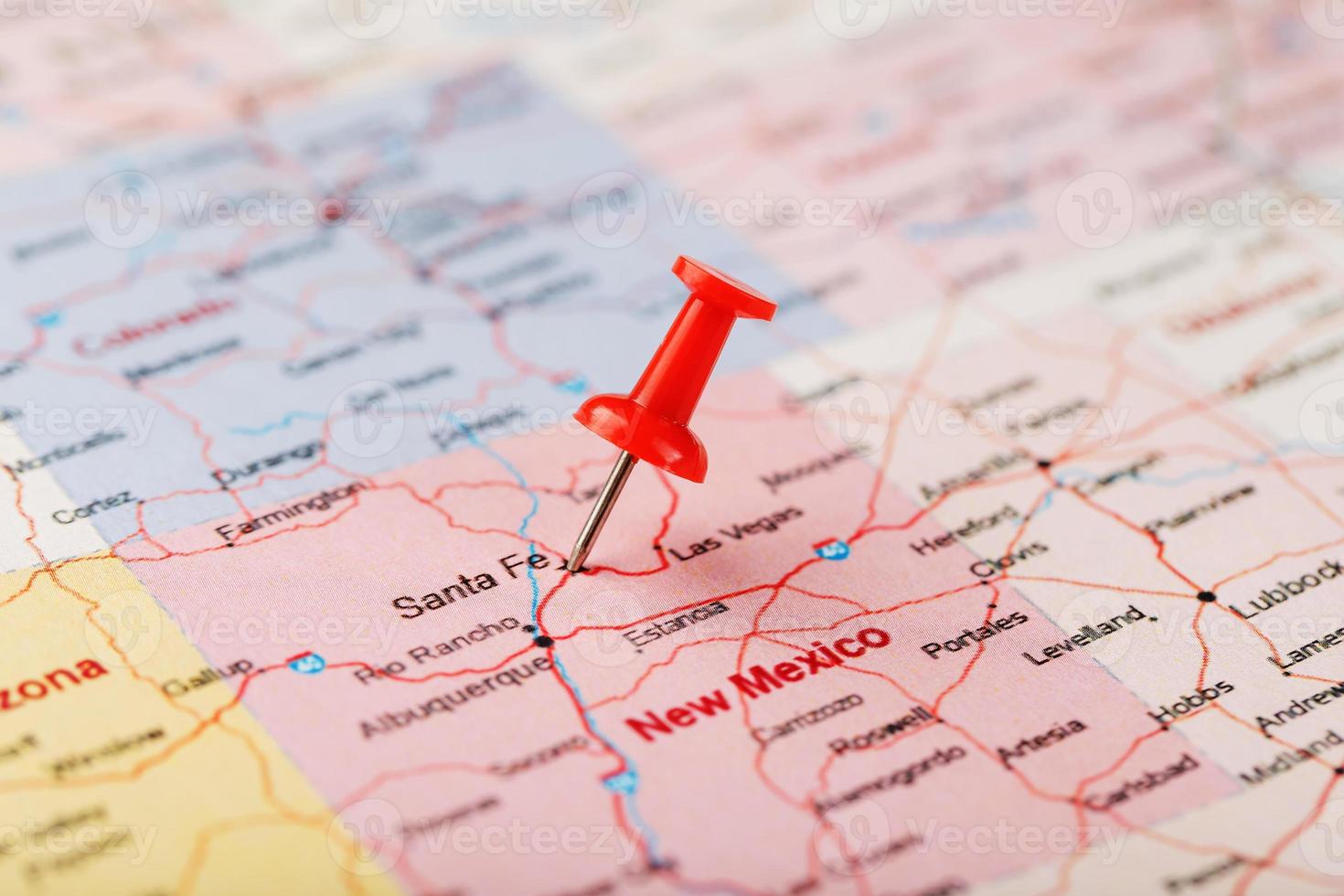 Red clerical needle on a map of USA, New Mexico and the capital of Santa Fe. Close up map of new mexico with red tack photo