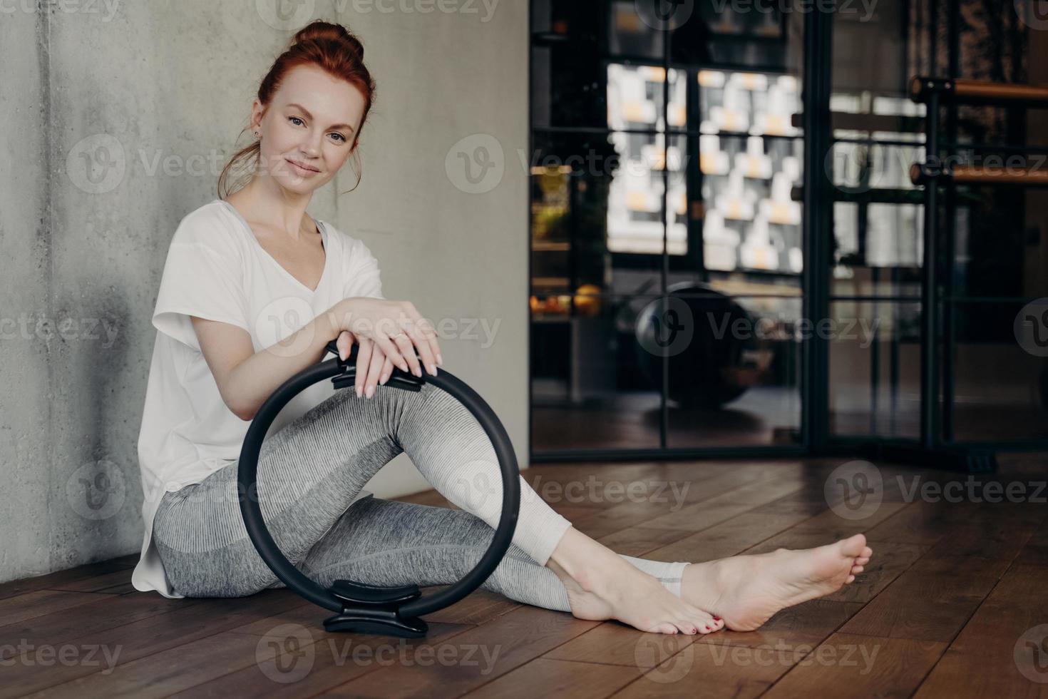 joven mujer deportiva posando con anillo de tonificación de pilates foto