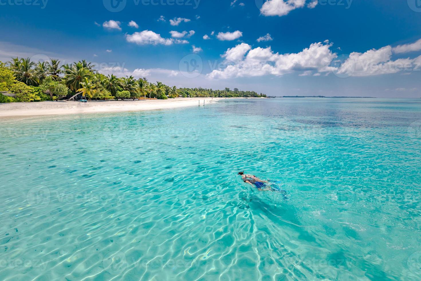 pareja caucásica de turistas bucean en agua cristalina turquesa cerca de la isla de maldivas. concepto de isla tropical y mar. área de esnórquel en arrecifes de coral con esnórquel en pareja foto