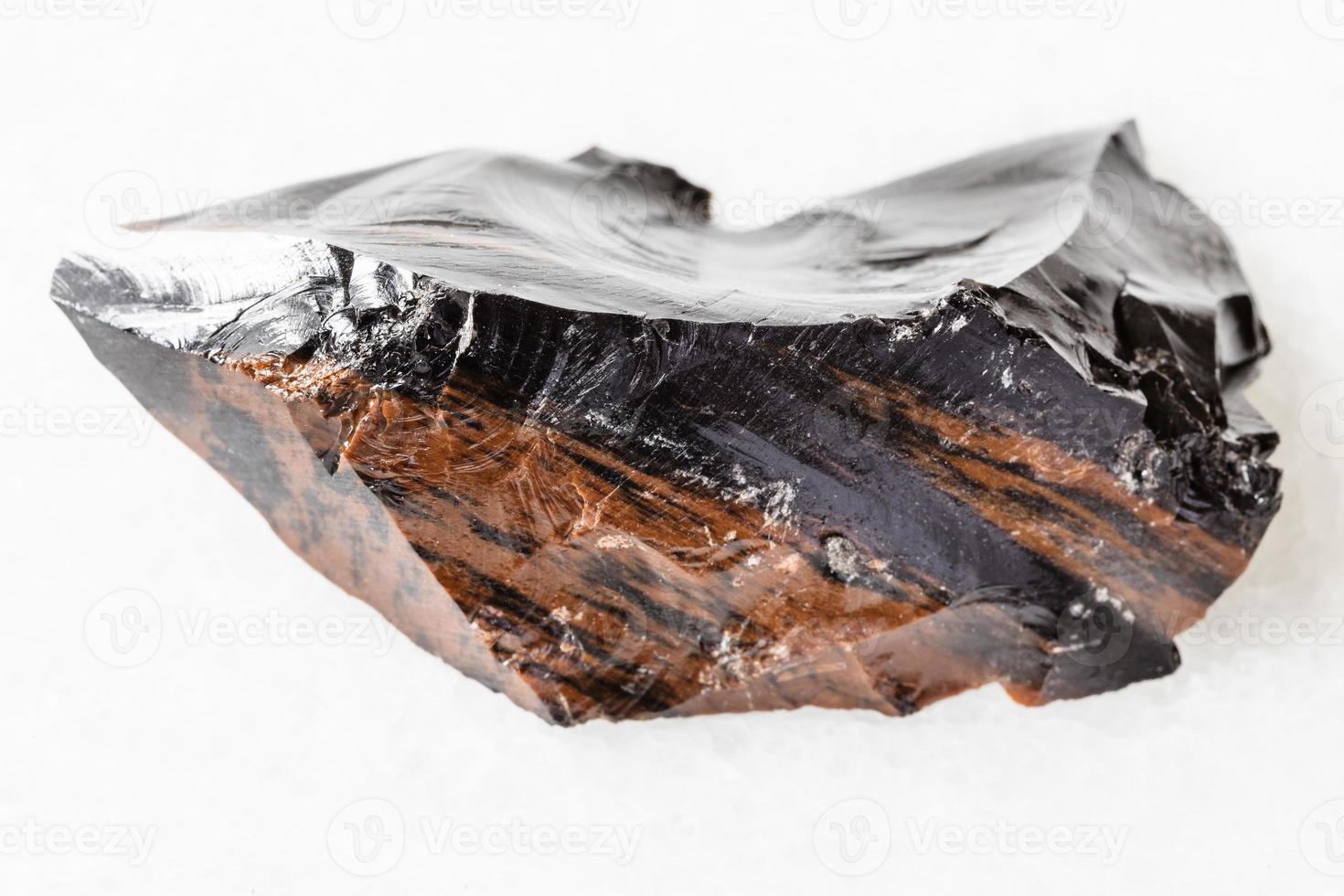 unpolished mahogany Obsidian on white marble photo