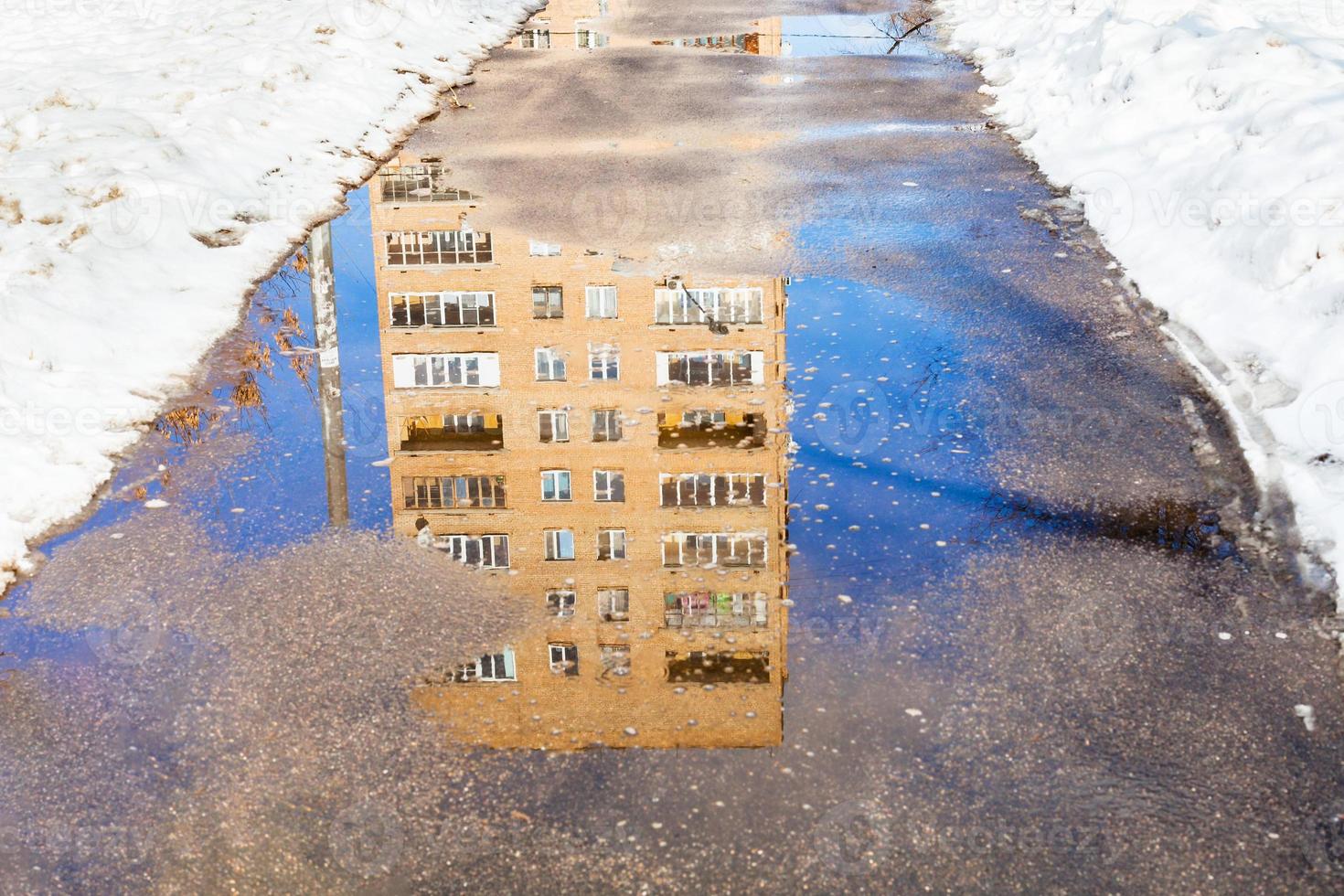 reflejo de la casa en un charco de nieve derretida foto