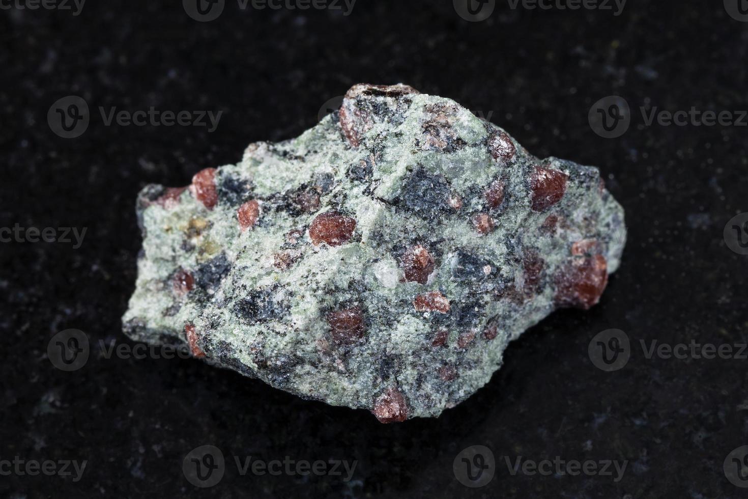 raw eclogite stone on dark g background photo