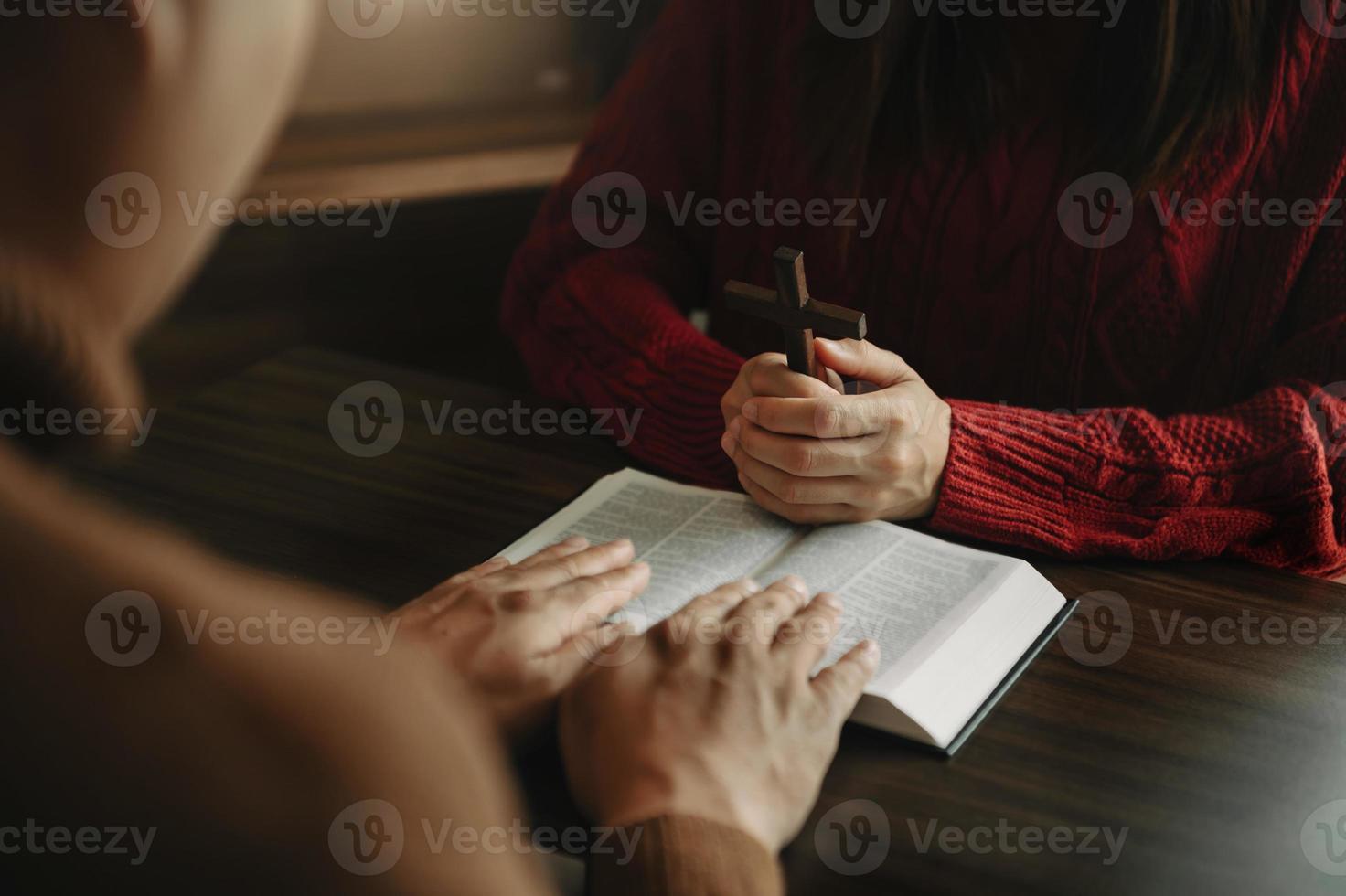 mano de mujer con cruz. concepto de esperanza, fe, cristianismo, religión, iglesia y oración a dios. en la mesa foto