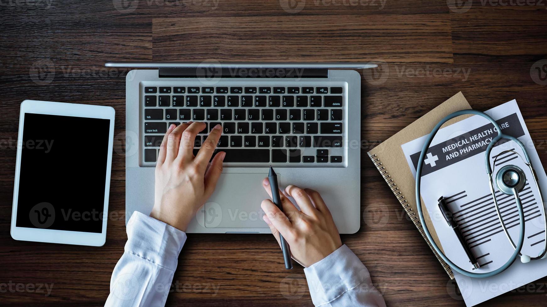 Top view table doctor. Health care and medical services with circular, laptop, tablet, and smartphone. top view of Medicine doctor hand working photo