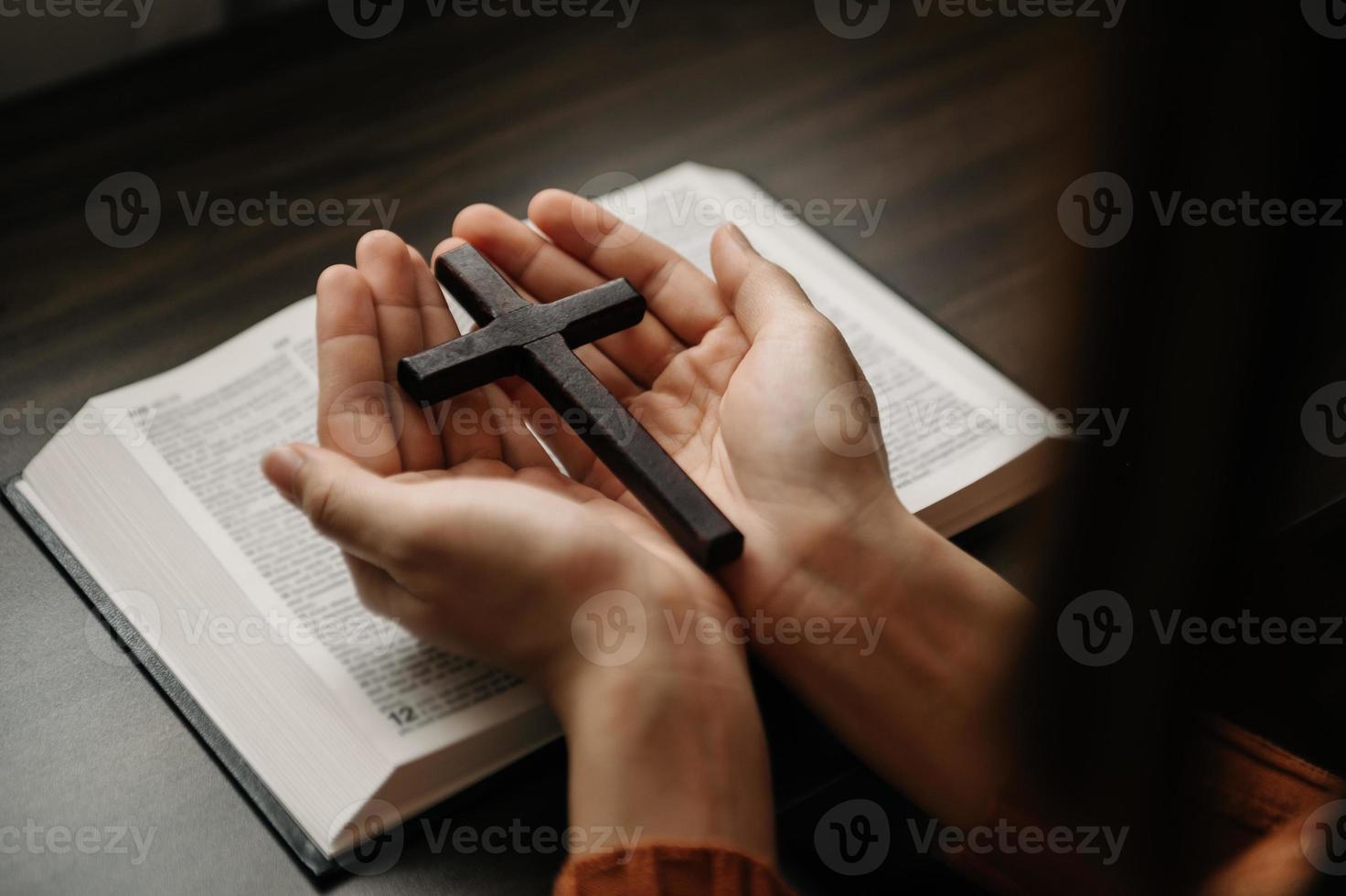 Woman sitting and studying the scriptures.The  wooden cross in the hands. Christian education concepts The Holy Scriptures open photo