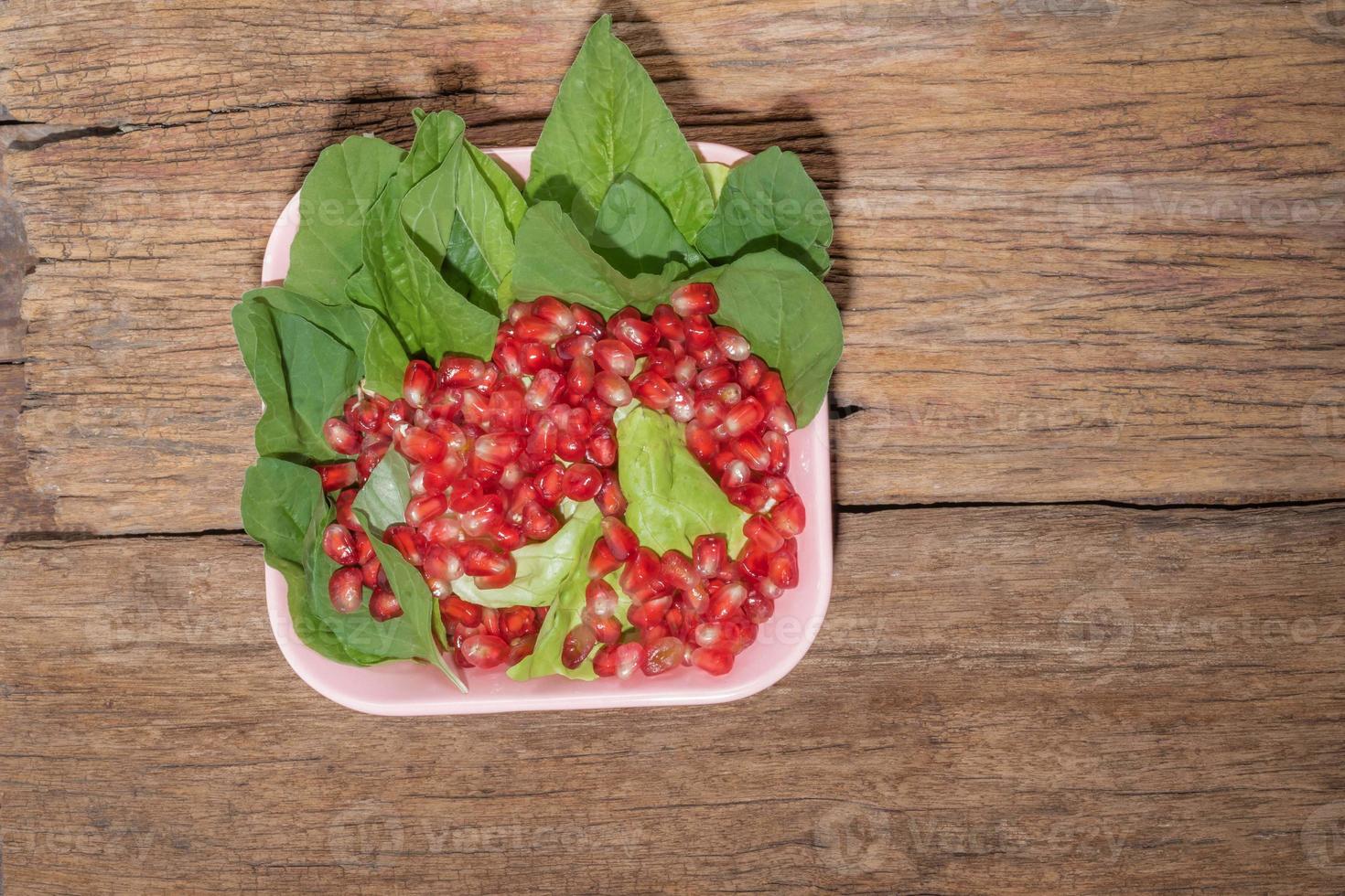 ensalada de verduras de alimentos saludables en un tazón rosa sobre fondo de madera. foto