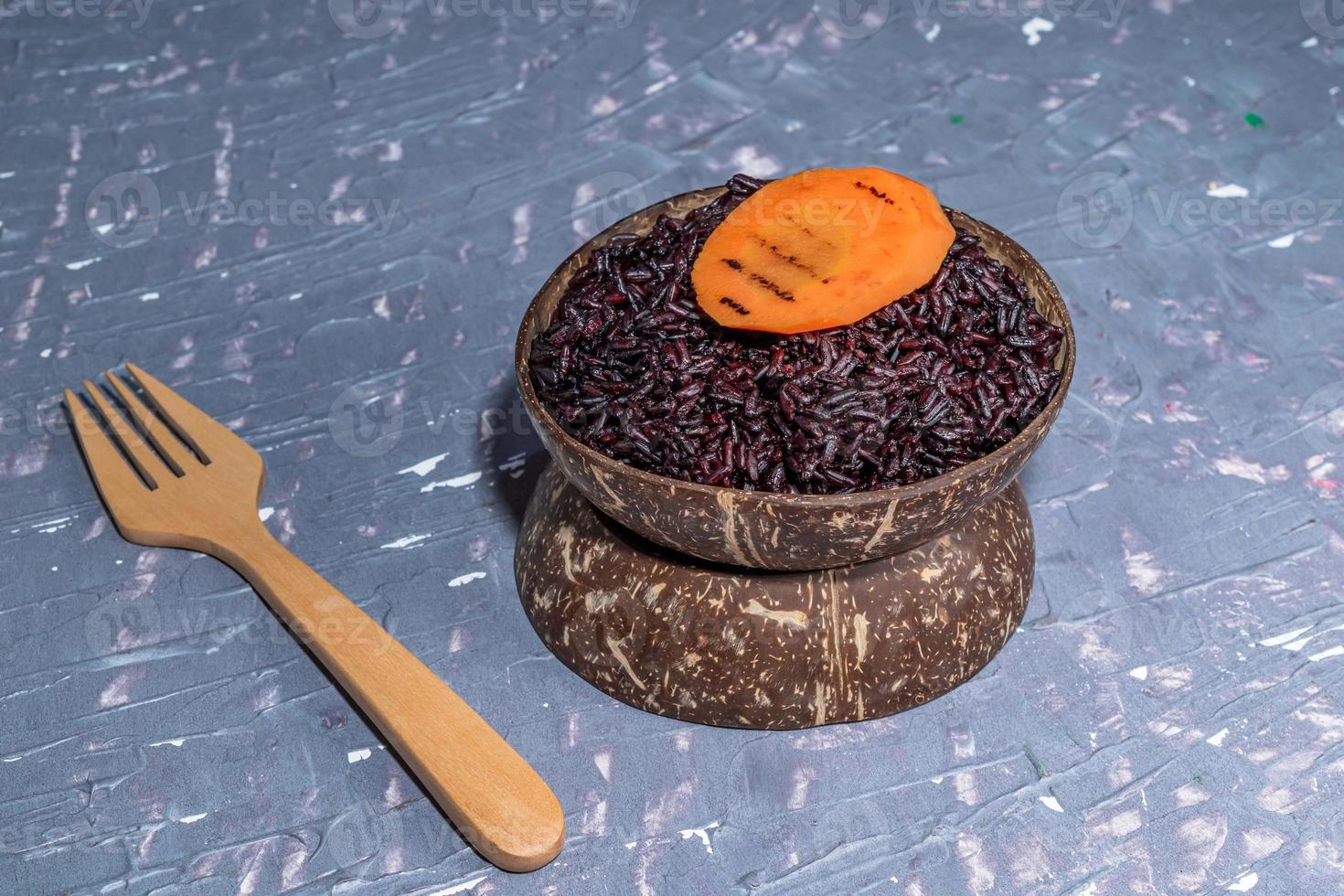 comida saludable arroz negro en tazón de coco tiene zanahoria. foto