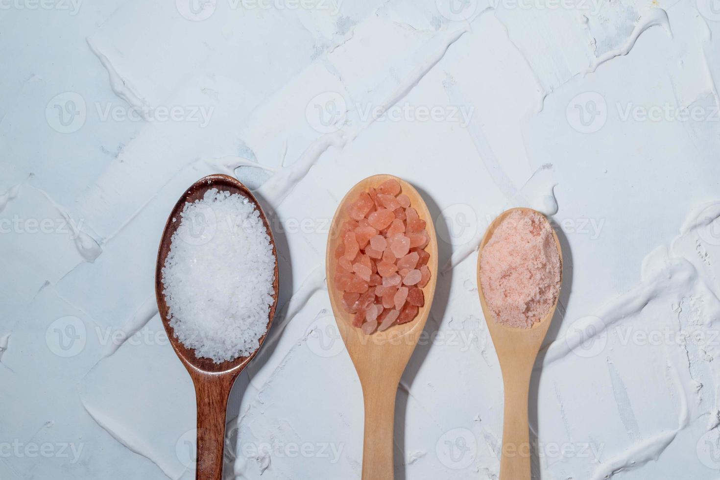 Kosher salt pink himalayan salt in spoon on white table. photo
