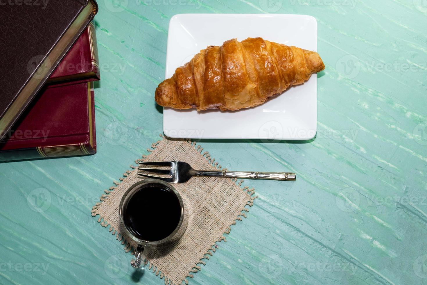 Espresso coffee and croissant in plate on green table h photo