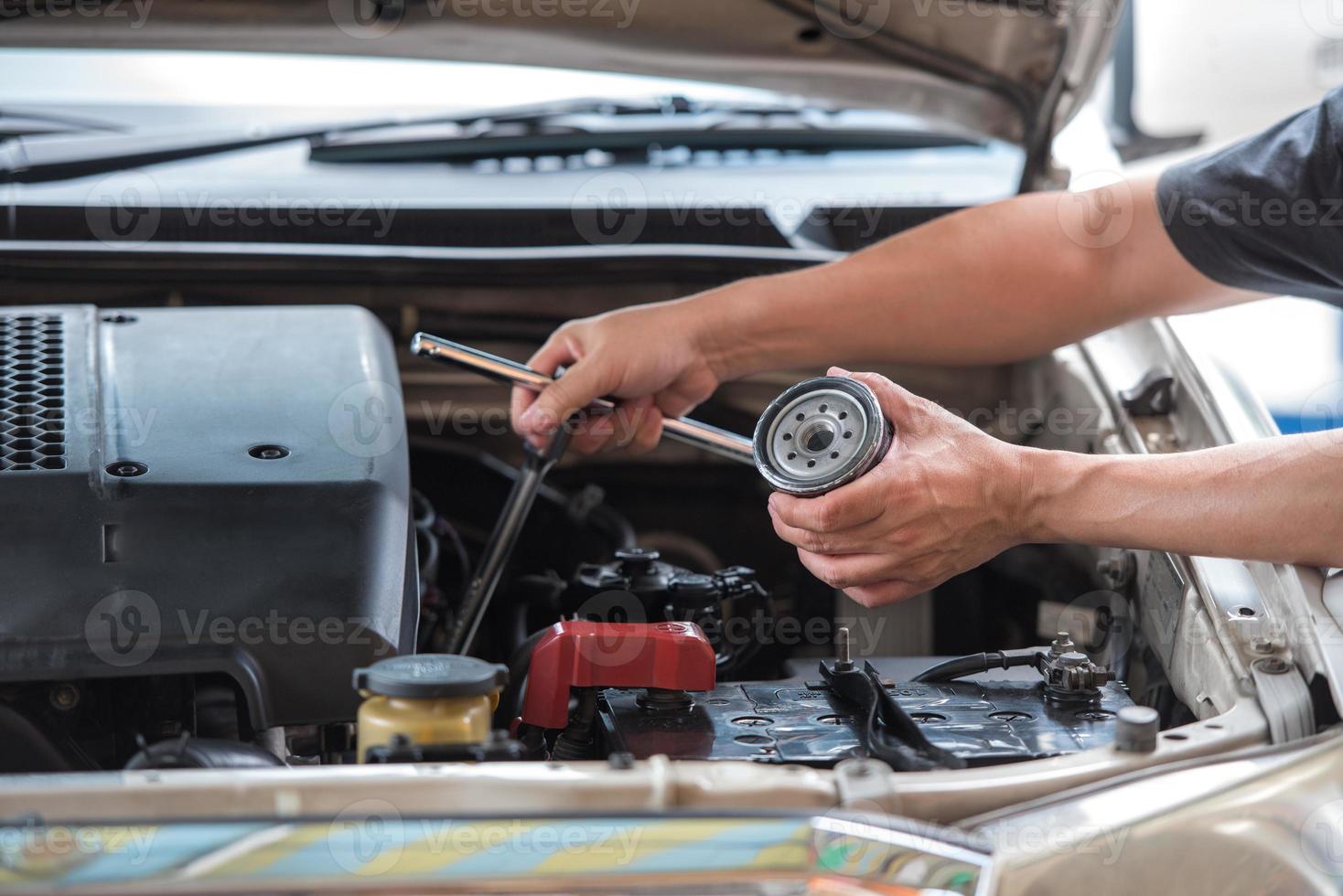 acción de las manos del hombre sosteniendo la llave de la tapa del filtro de aceite y el filtro de aceite automotriz preparándose para cambiar el nuevo concepto de servicio de mantenimiento y reparación de automóviles. foto