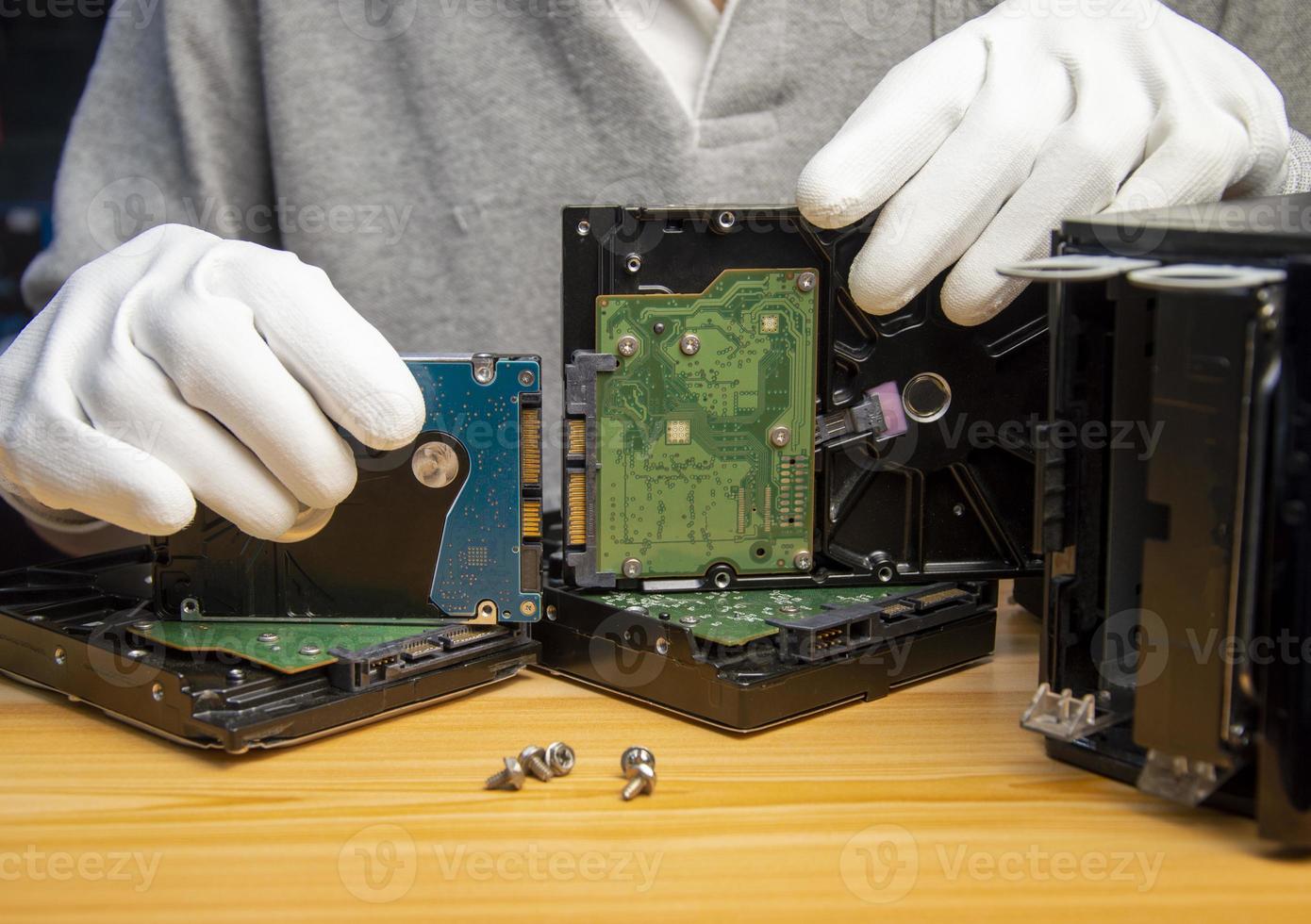 Rotating hard drives are still popular in use today, the technician is holding a hard drive in hand. photo