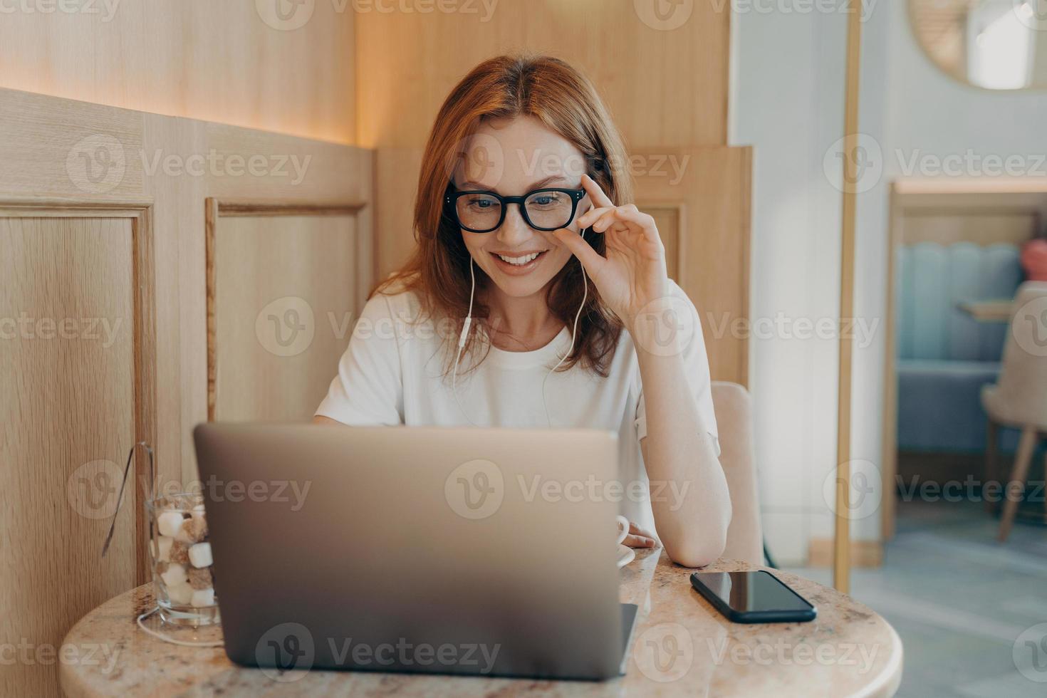 Woman remote worker looks in laptop screen photo