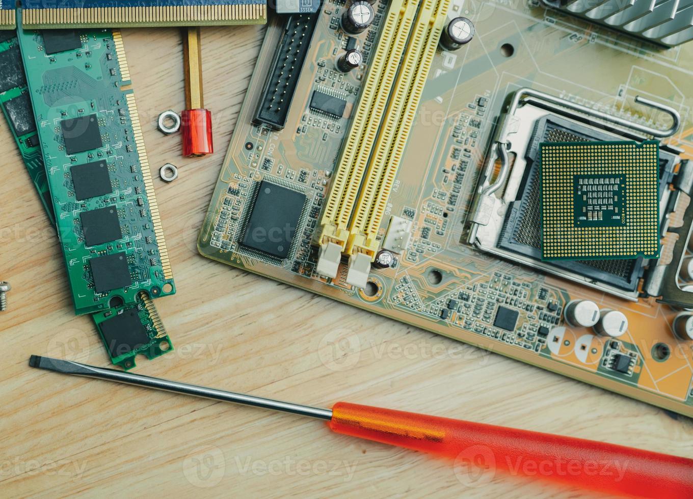 Computer chip on electronic circuit board of PC motherboard and screwdriver at repair workshop. Top view CPU chipset on table. Electronic components. Computer hardware. Upgrade computer processor chip photo