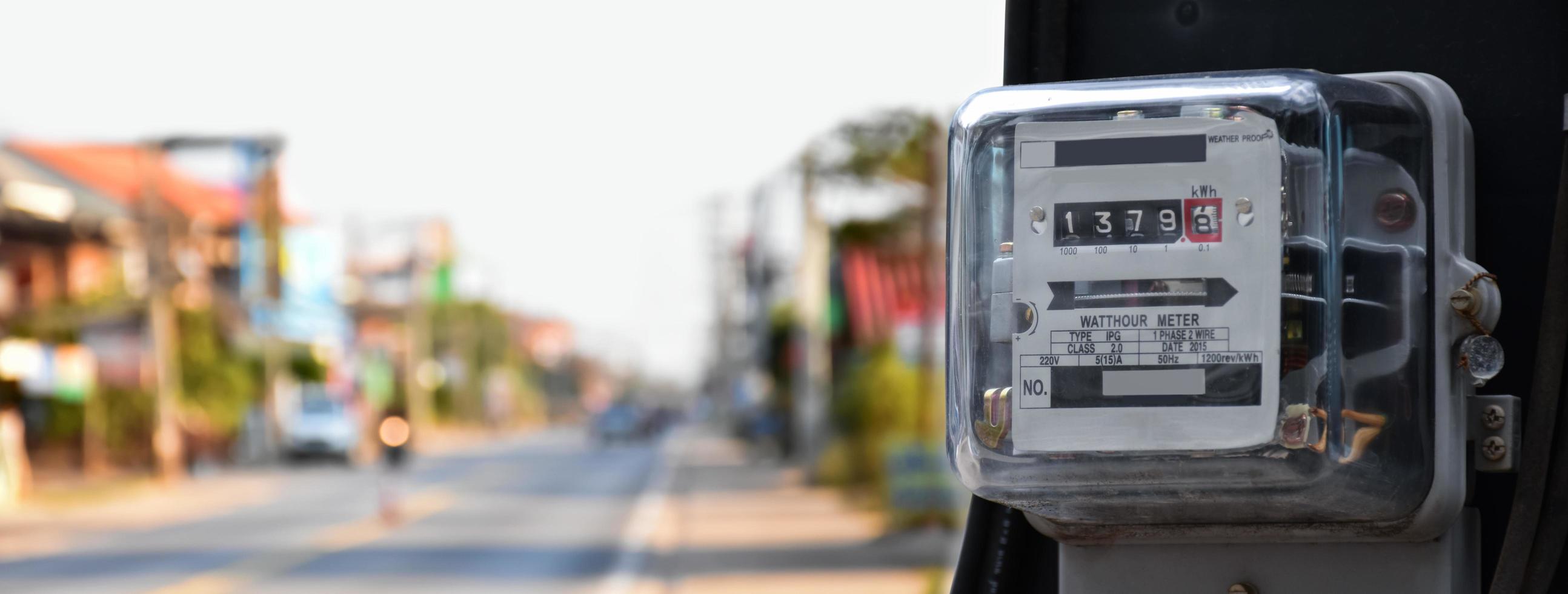 Watthour meter or electricity meter on pole to record the monthly electricity consumption of the inhabitants of each houses in the Southeast Asian countries, soft and selective focus on meter. photo