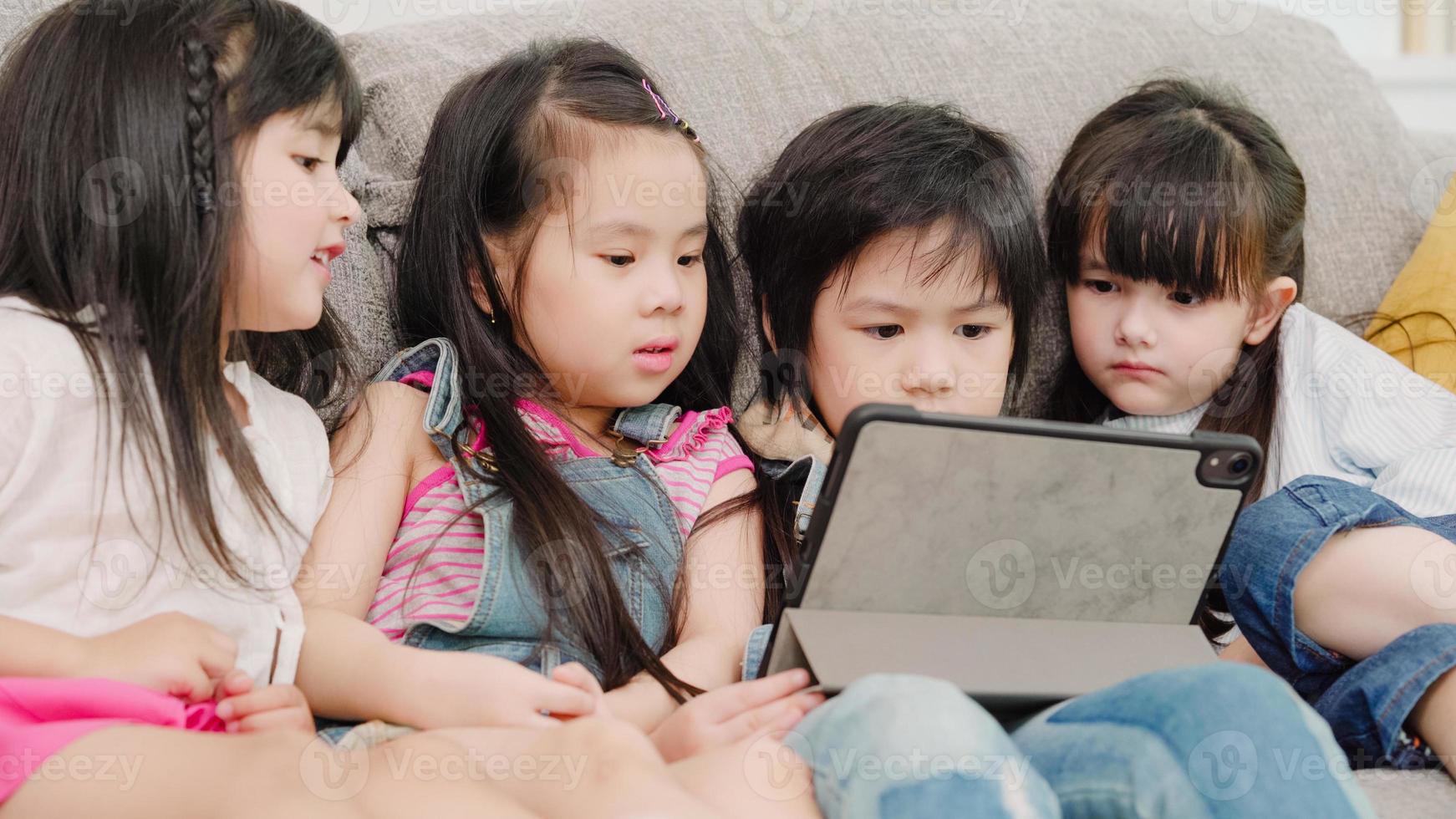 Group of children using tablet in classroom, Multi-ethnic young boys and girls happy using technology for study and play games at elementary school. Kids use technology for education concept. photo