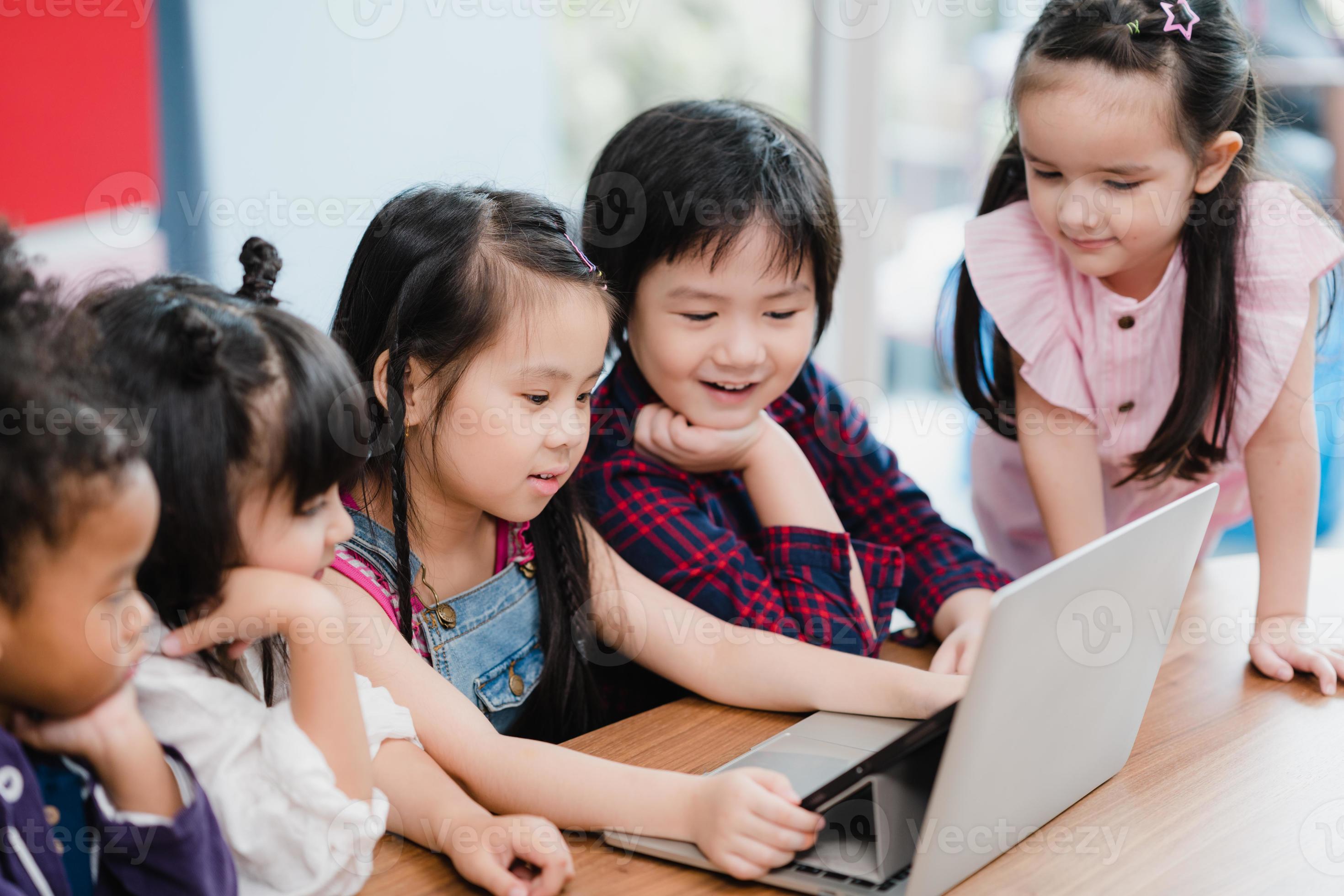 Group of children using laptop in classroom, Multiethnic young boys