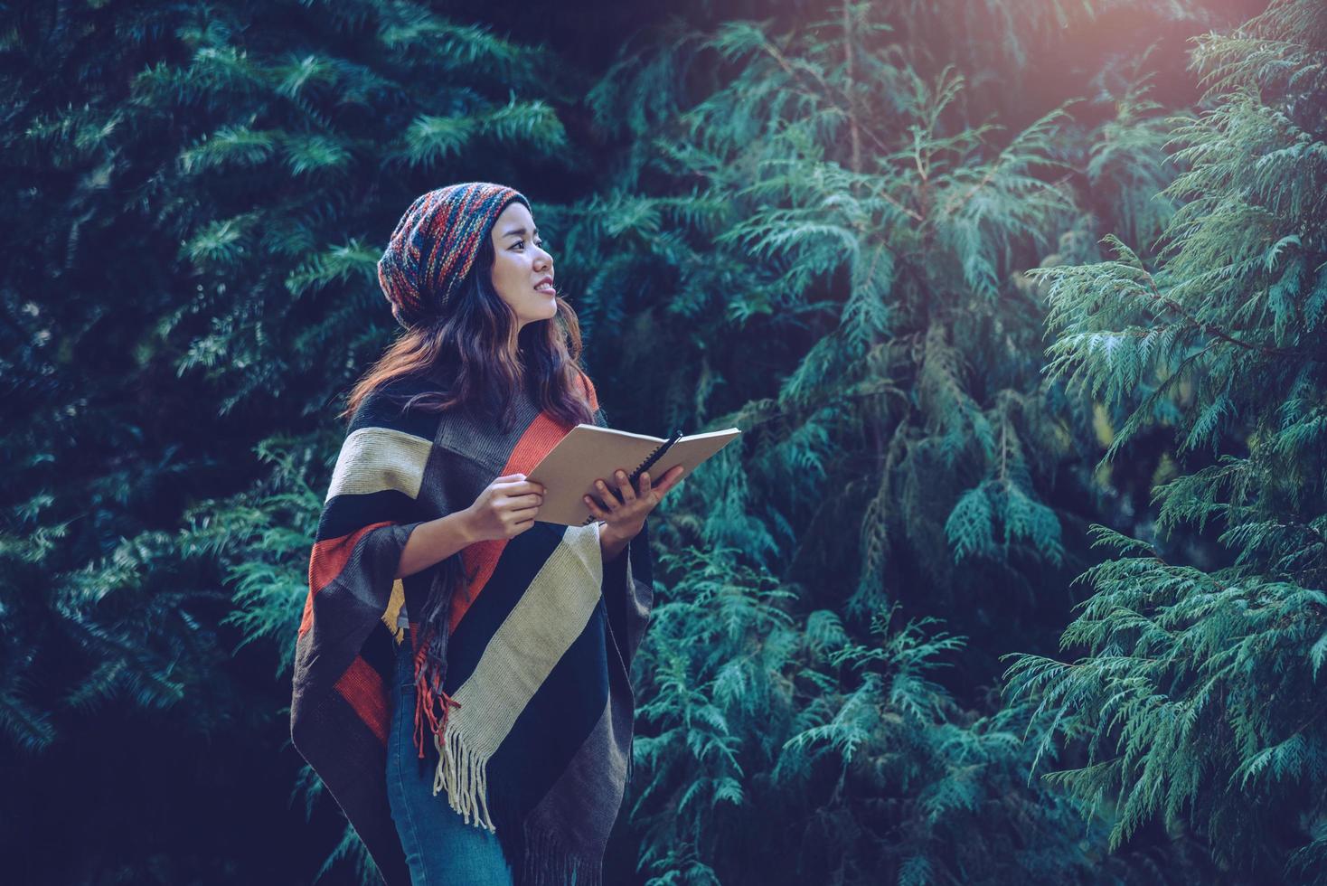 Young woman relax in the holiday. Travel nature and  write a note Happy to see the beauty of the pine leaf. Nature Study. photo