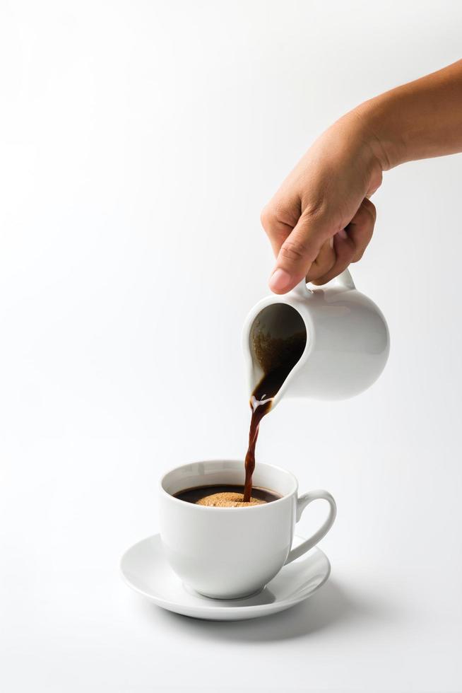 Pouring coffee on a cup isolated on white background photo