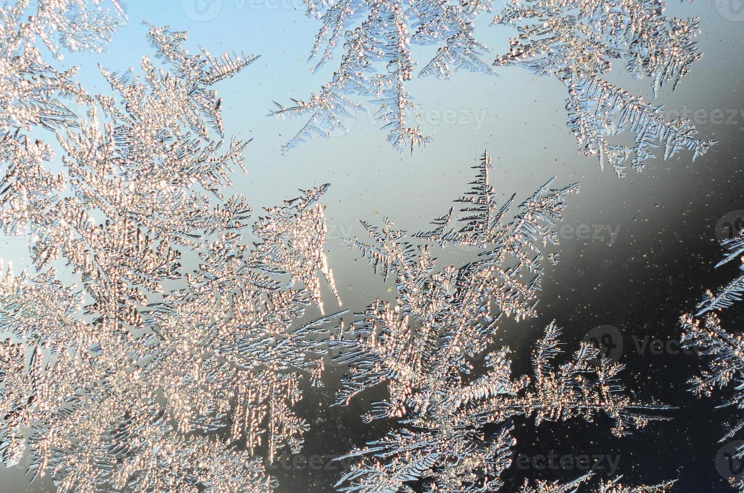 Snowflakes frost rime macro on window glass pane photo