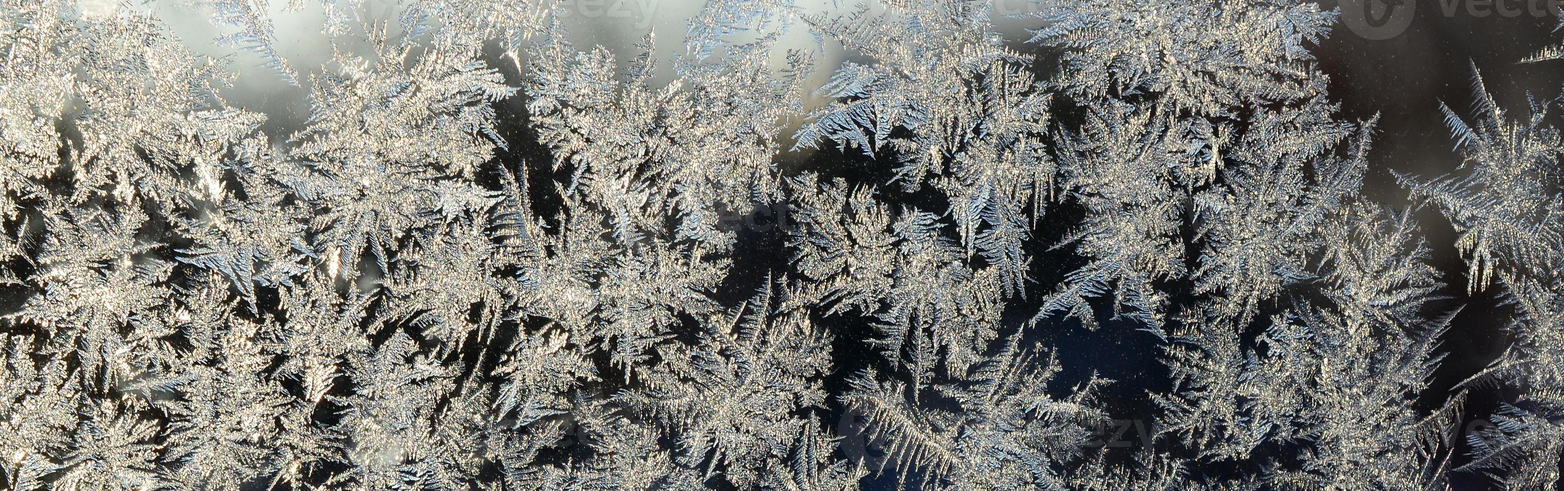 Snowflakes frost rime macro on window glass pane photo