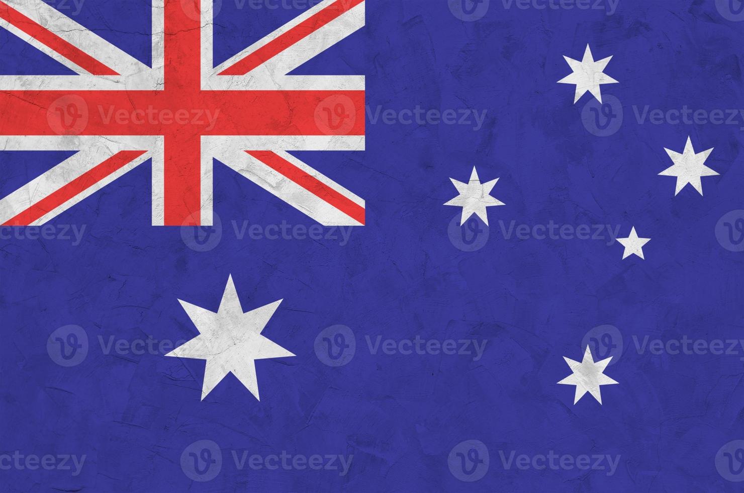 Australia flag depicted in bright paint colors on old relief plastering wall. Textured banner on rough background photo